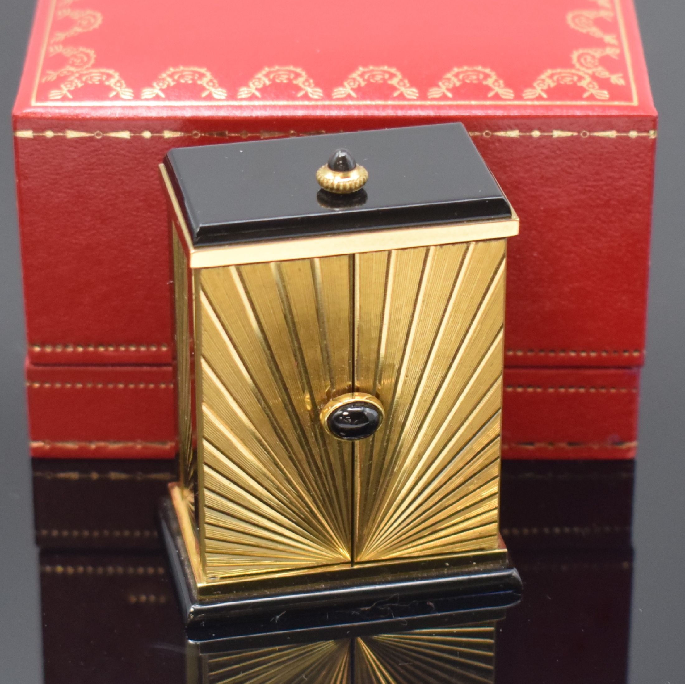 Detail b: CARTIER kleiner Tischwecker, Schweiz um 1980, quarz, verg. Geh. m. Sonnendekor teils schwarz lackiert, Schmuckkrone, aufklappbar, röm. Zahlen, ...