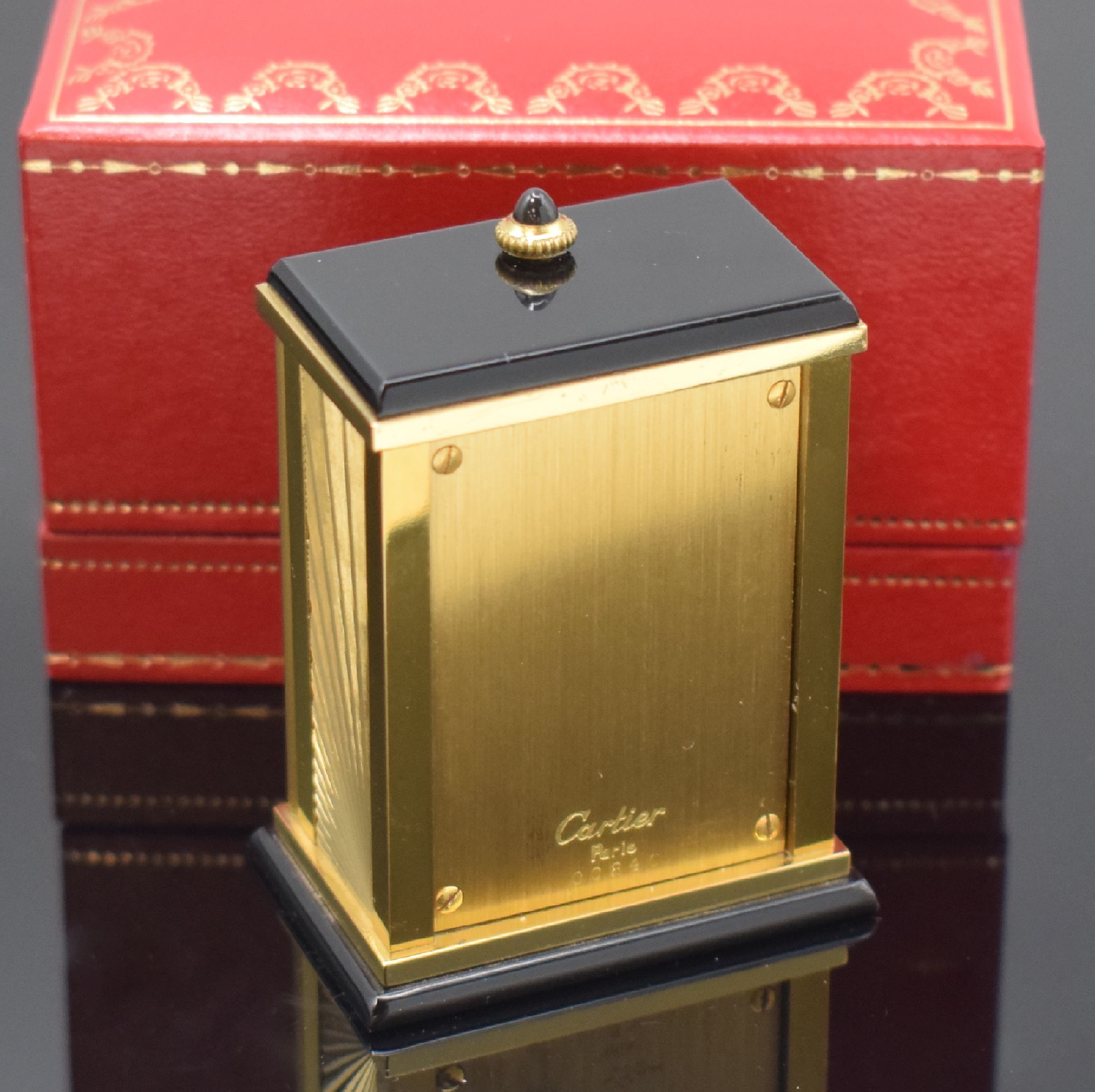 Detail d: CARTIER kleiner Tischwecker, Schweiz um 1980, quarz, verg. Geh. m. Sonnendekor teils schwarz lackiert, Schmuckkrone, aufklappbar, röm. Zahlen, ...