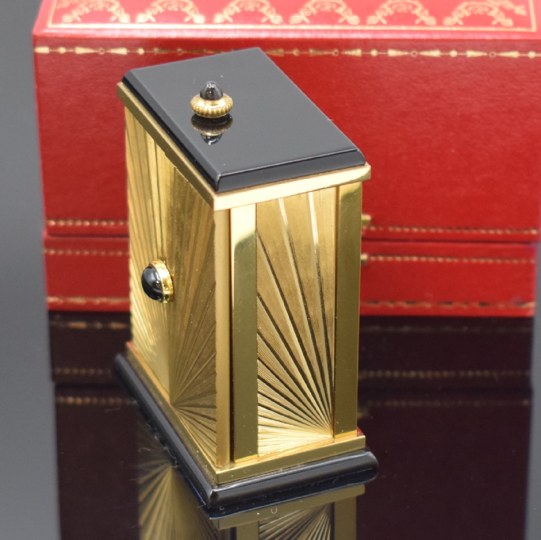 Detail e: CARTIER kleiner Tischwecker, Schweiz um 1980, quarz, verg. Geh. m. Sonnendekor teils schwarz lackiert, Schmuckkrone, aufklappbar, röm. Zahlen, ...