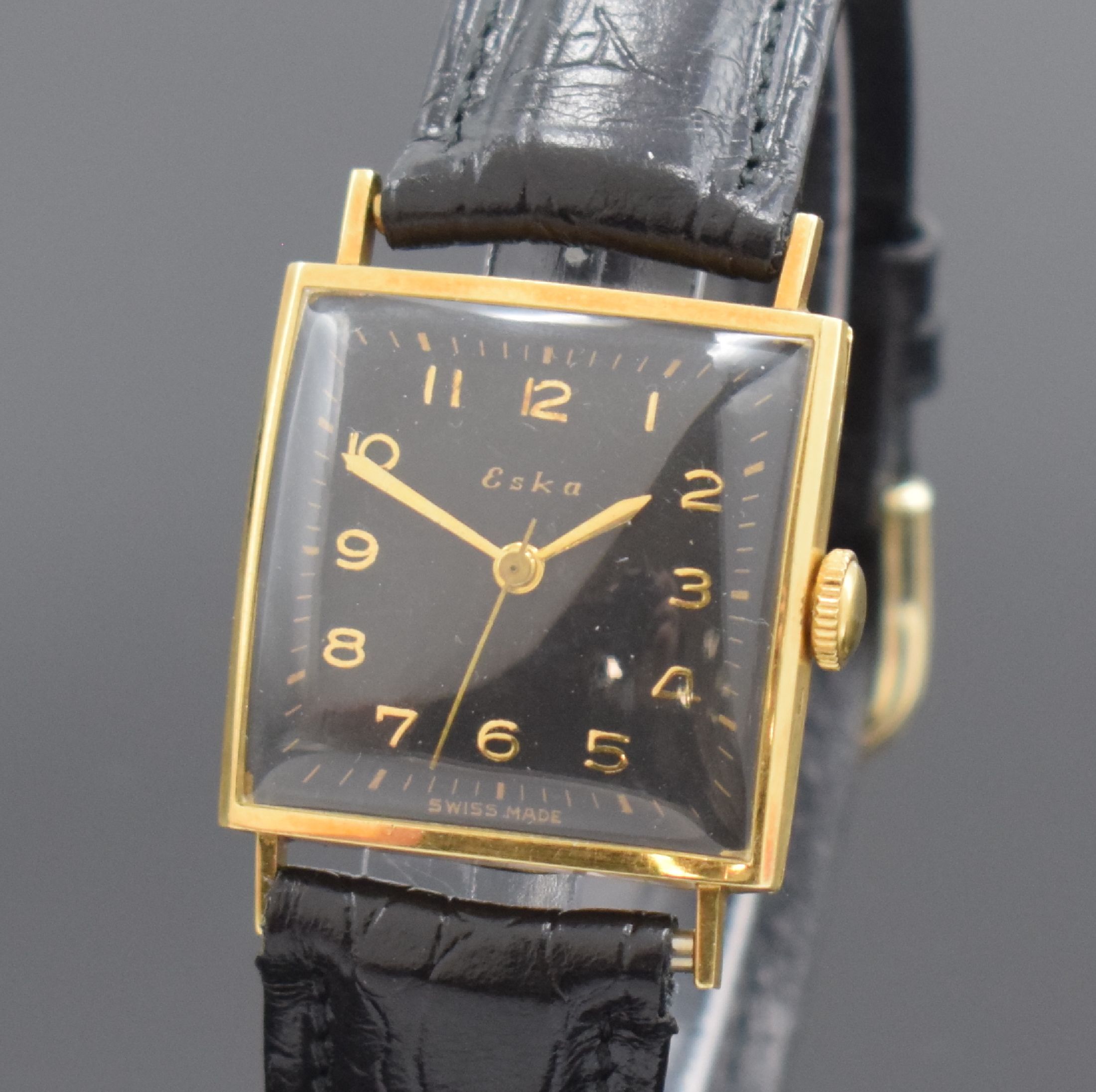 Detail a: ESKA viereckige Armbanduhr in GG 750/000, Schweiz um 1955, Handaufzug, Boden m. Widmung aufgedr., schwarzes Zifferbl. rest., arab. Zahlen, gold. ...