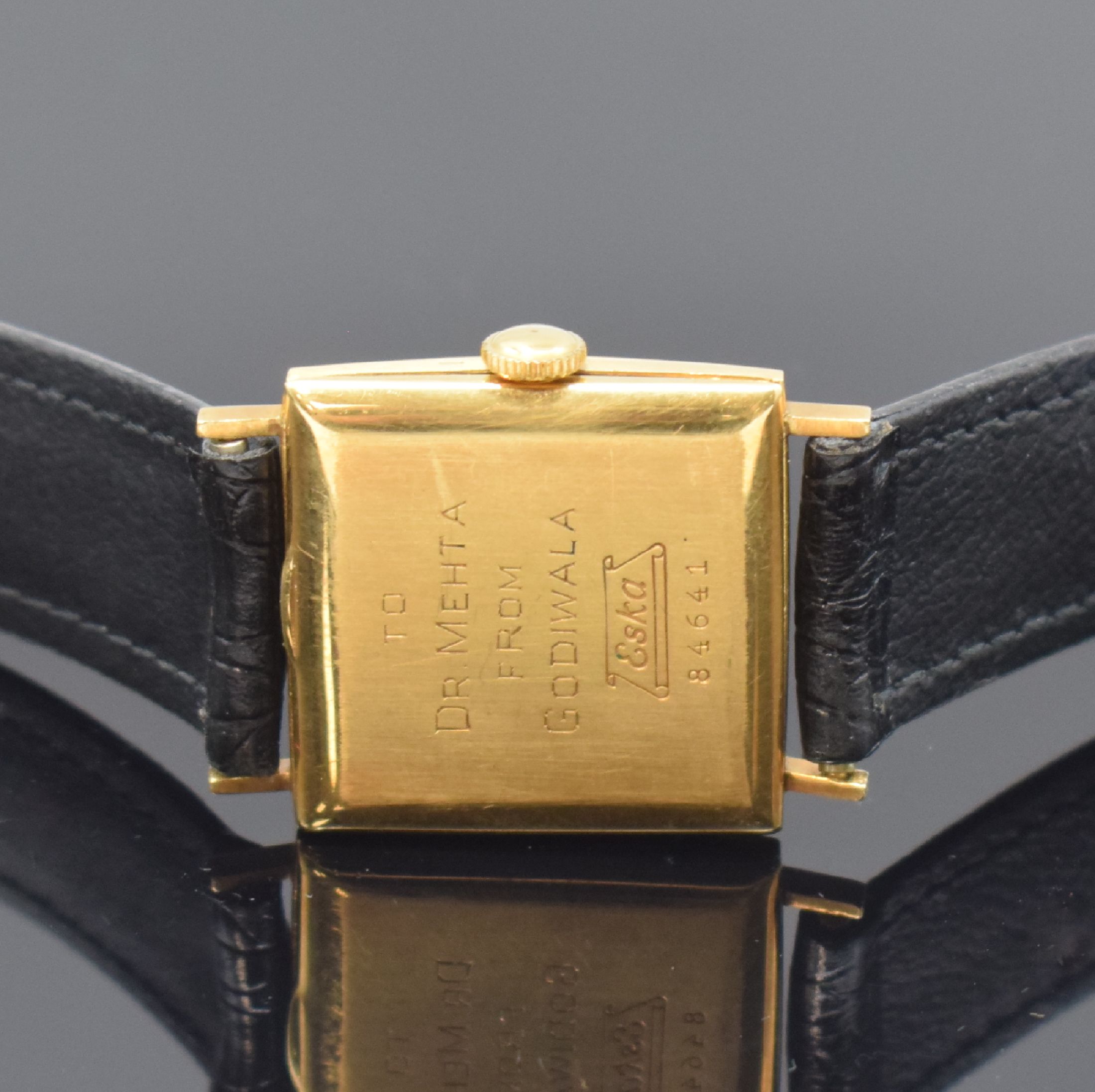 Detail c: ESKA viereckige Armbanduhr in GG 750/000, Schweiz um 1955, Handaufzug, Boden m. Widmung aufgedr., schwarzes Zifferbl. rest., arab. Zahlen, gold. ...