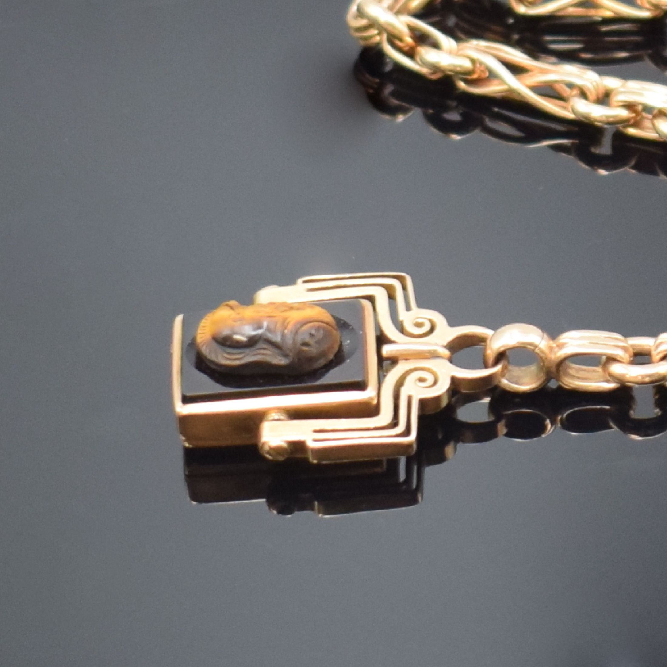 Detail a: Taschenuhrkette in RG 585/000 mit Petschaft,um 1900, Karabiner und Federring, Petschaft- Anhänger mit Lagenstein, darauf plastisch gearbeiteter Kopf ...