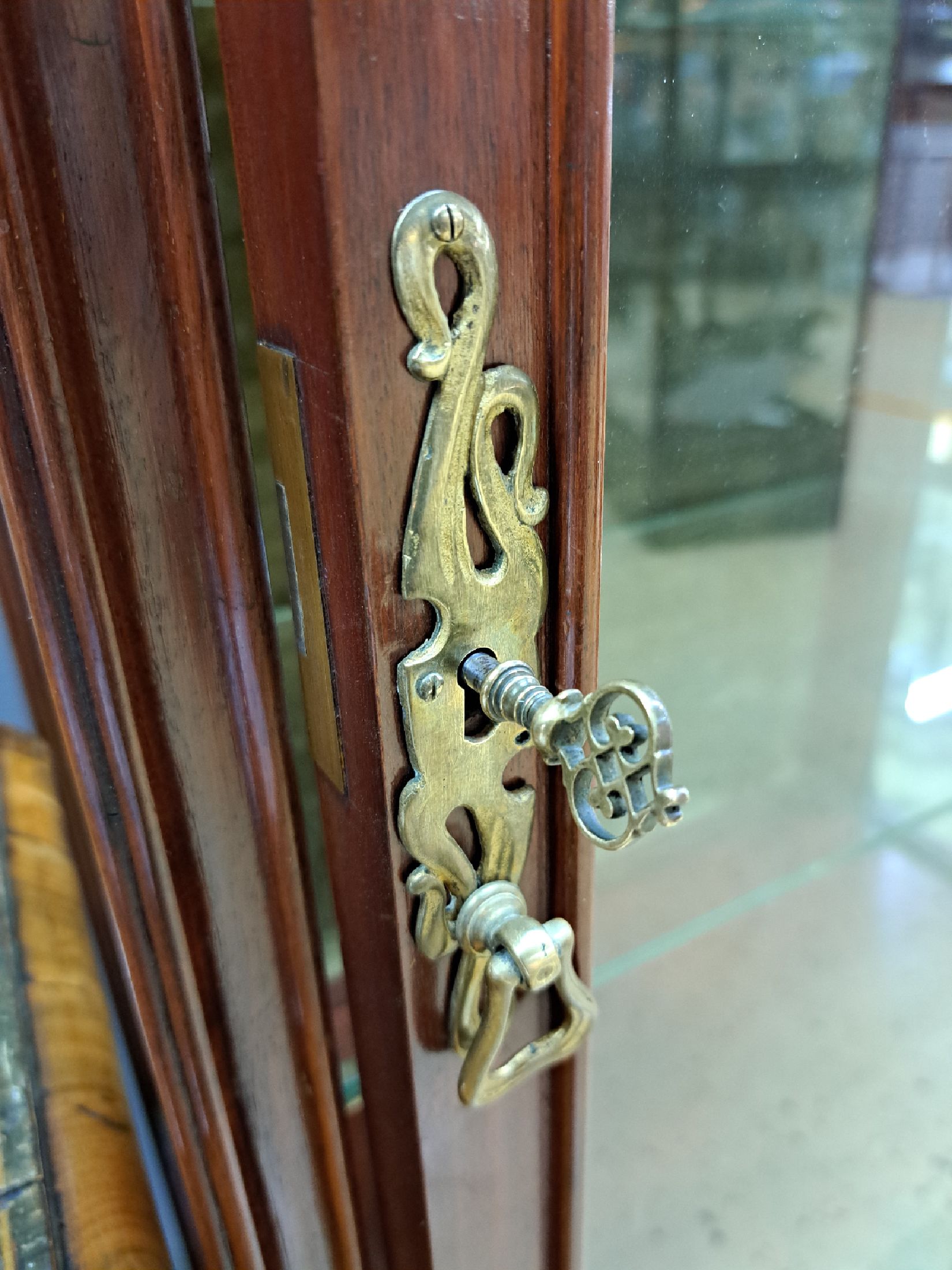 Detail d: Jugendstil-Vitrine, Anfang 20.Jh., Mahagoni, verglaste Tür, floraler Reliefdekor, 1-schübig, Schlüssel vorhanden, 180x70x40 cm, EZ 2-3