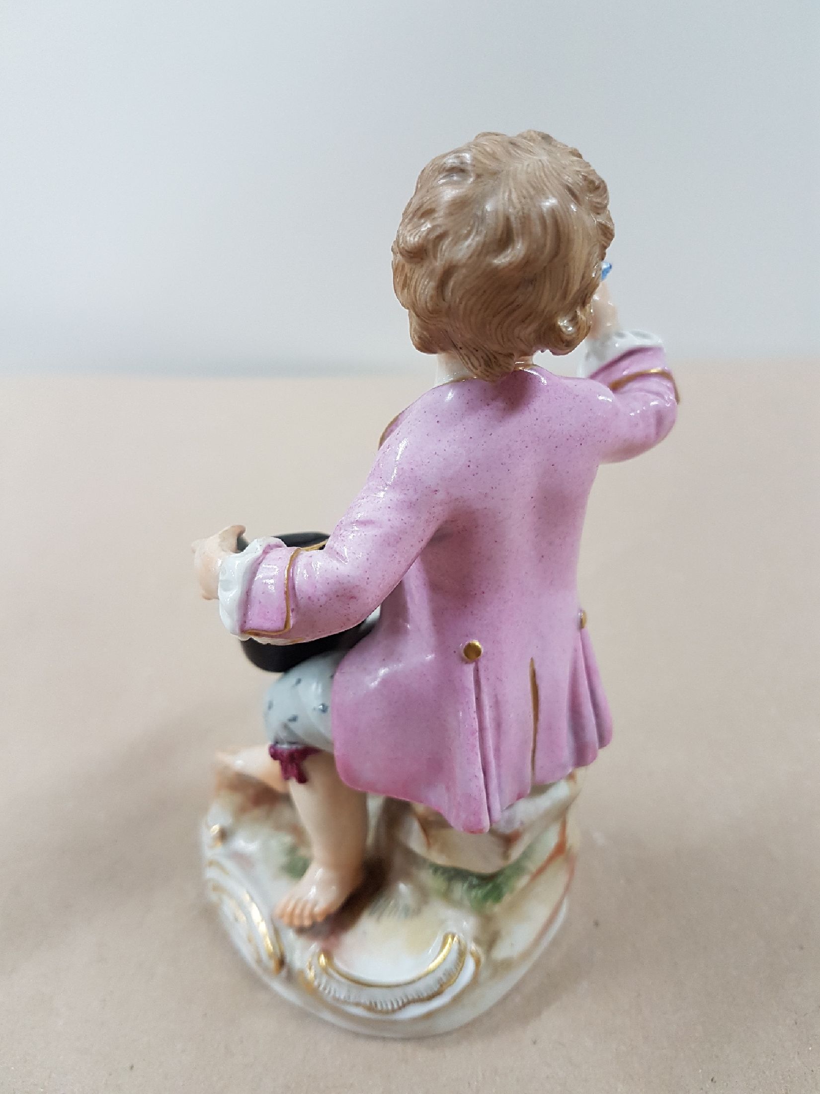 Detail c: Porzellanfigur, Meissen, um 1900, sitzender Knabe mit Rosenstrauß, polychrome Bemalung, Goldstaffage, an den Blüten und Blättern best., H. ca. 12 ...