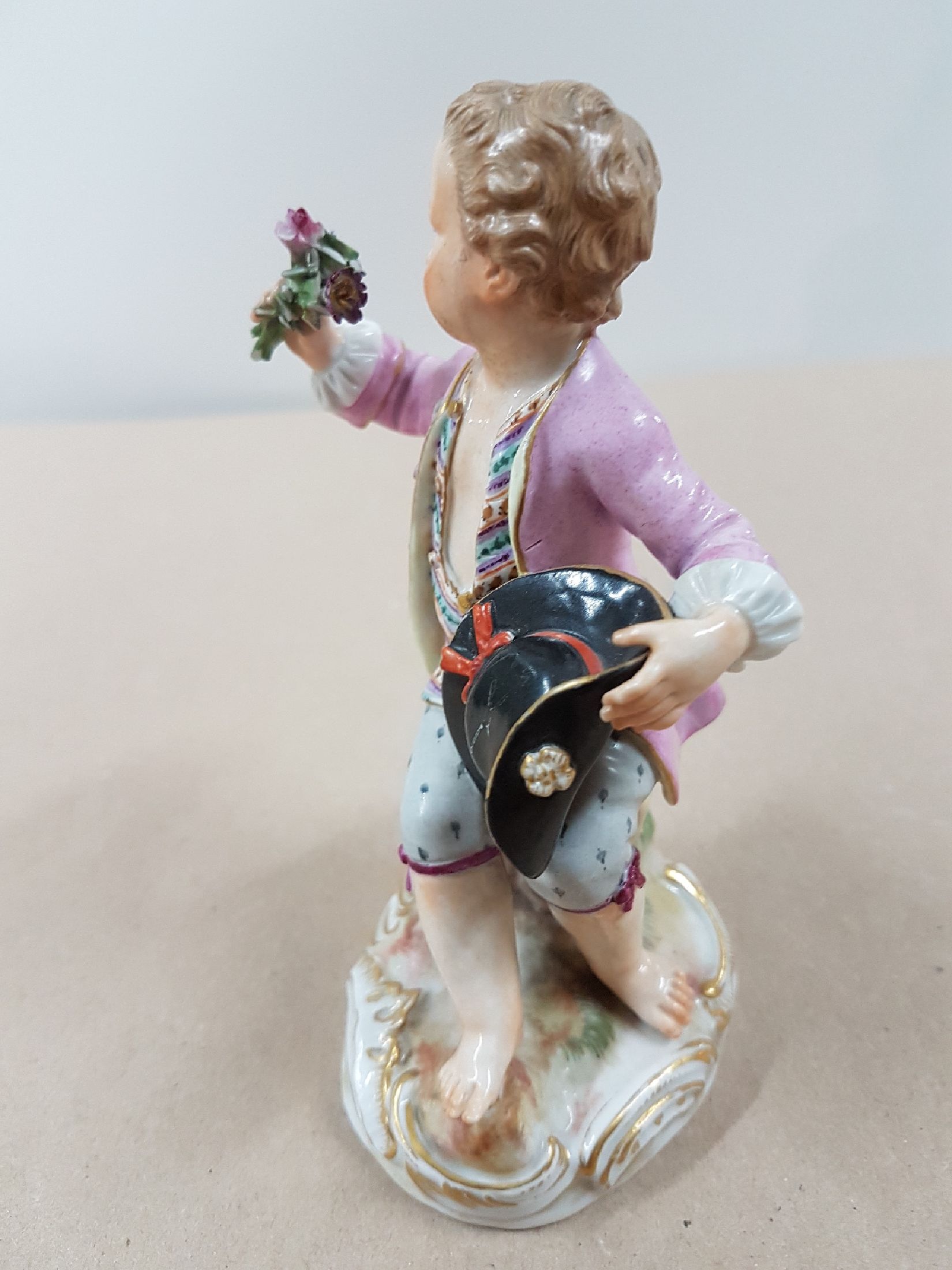 Detail d: Porzellanfigur, Meissen, um 1900, sitzender Knabe mit Rosenstrauß, polychrome Bemalung, Goldstaffage, an den Blüten und Blättern best., H. ca. 12 ...