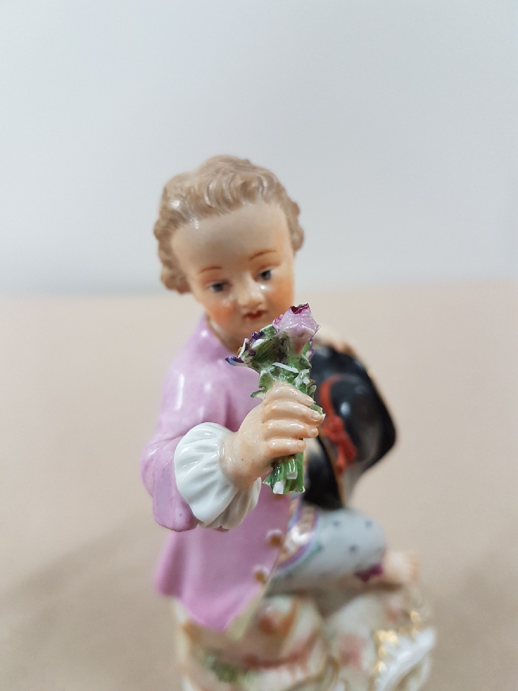 Detail e: Porzellanfigur, Meissen, um 1900, sitzender Knabe mit Rosenstrauß, polychrome Bemalung, Goldstaffage, an den Blüten und Blättern best., H. ca. 12 ...