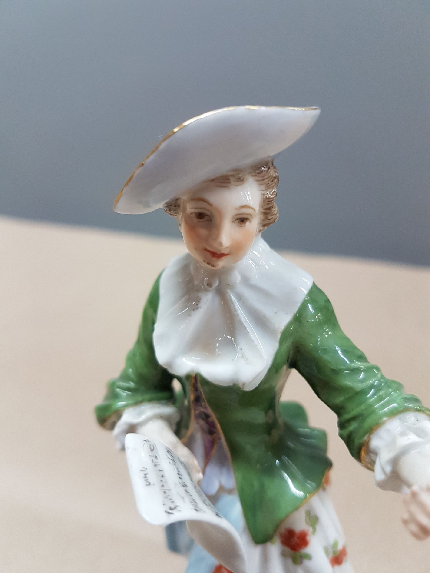 Detail e: Porzellanfigur, Meissen, Entwurf Johann Elias Meyer, vor 1924, Sängerin aus der galanten Kapelle, polychrom bemalt, Goldstaffage, H. ca. 14 cm