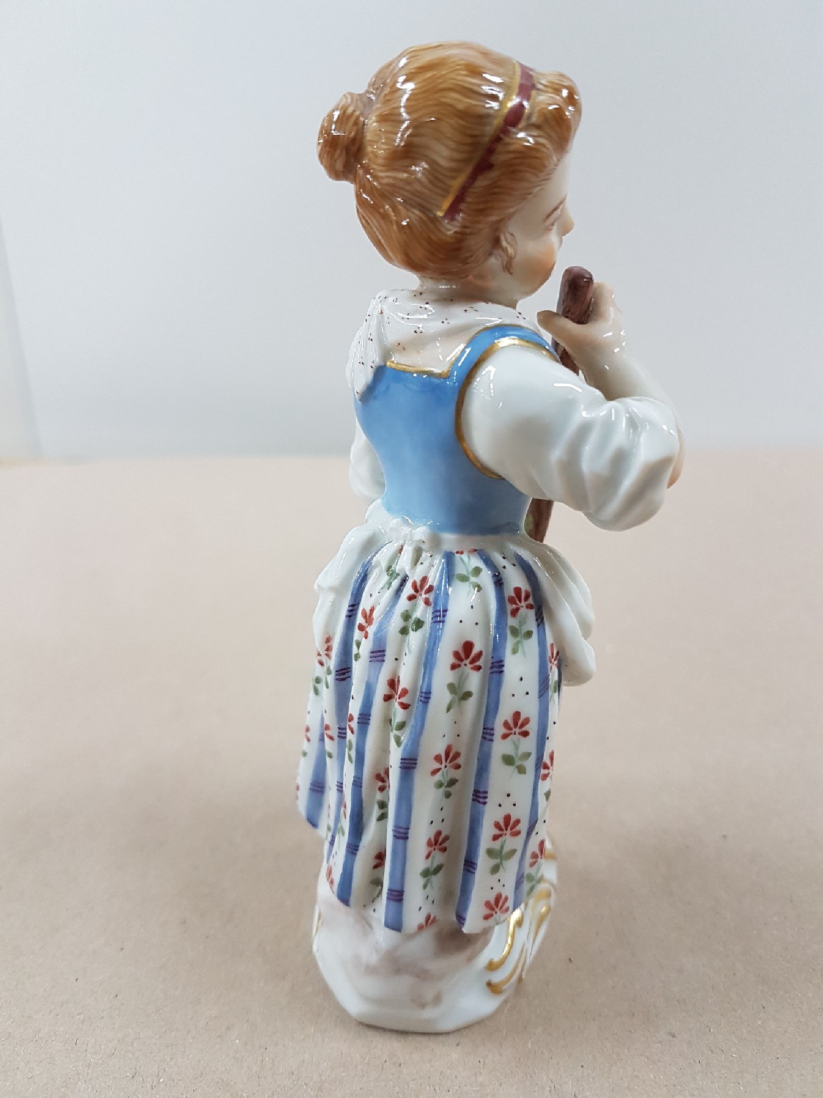 Detail b: Porzellanfigur, Meissen, 20. Jh., Gärtnerin mit Rechen, Modellnr. 60353, bunt bemalt, Goldstaffage, ca. 13 cm