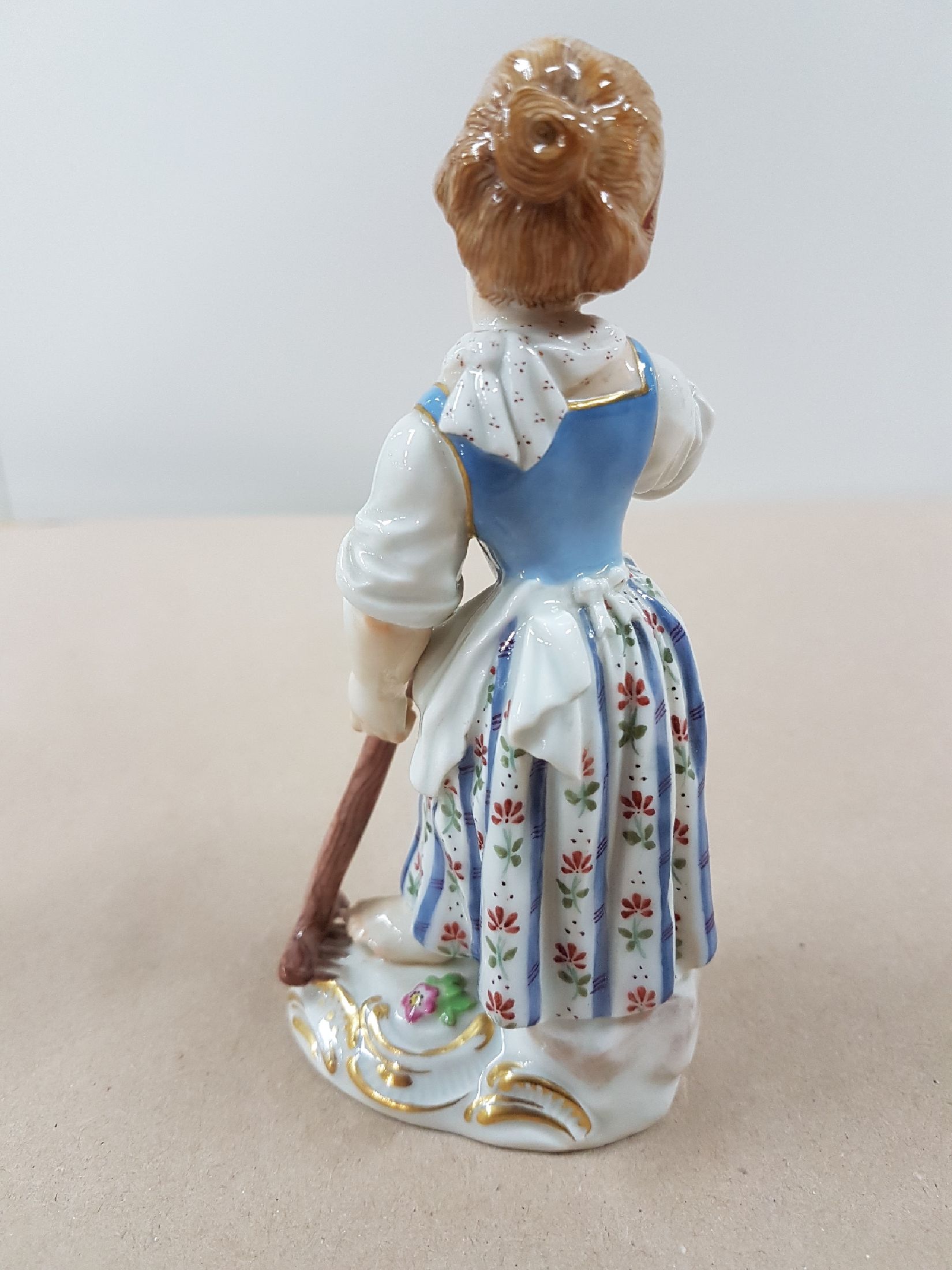 Detail c: Porzellanfigur, Meissen, 20. Jh., Gärtnerin mit Rechen, Modellnr. 60353, bunt bemalt, Goldstaffage, ca. 13 cm
