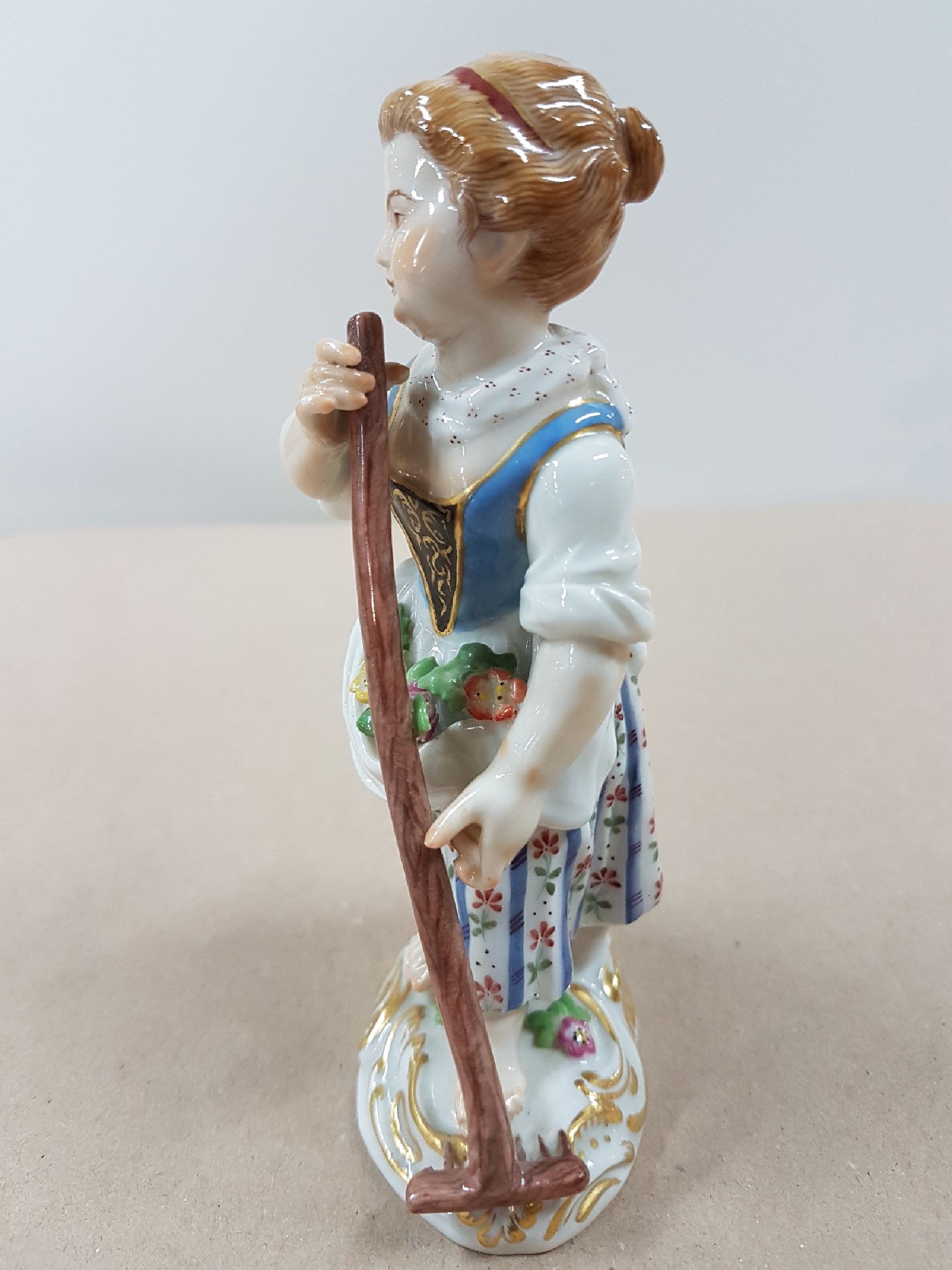 Detail d: Porzellanfigur, Meissen, 20. Jh., Gärtnerin mit Rechen, Modellnr. 60353, bunt bemalt, Goldstaffage, ca. 13 cm