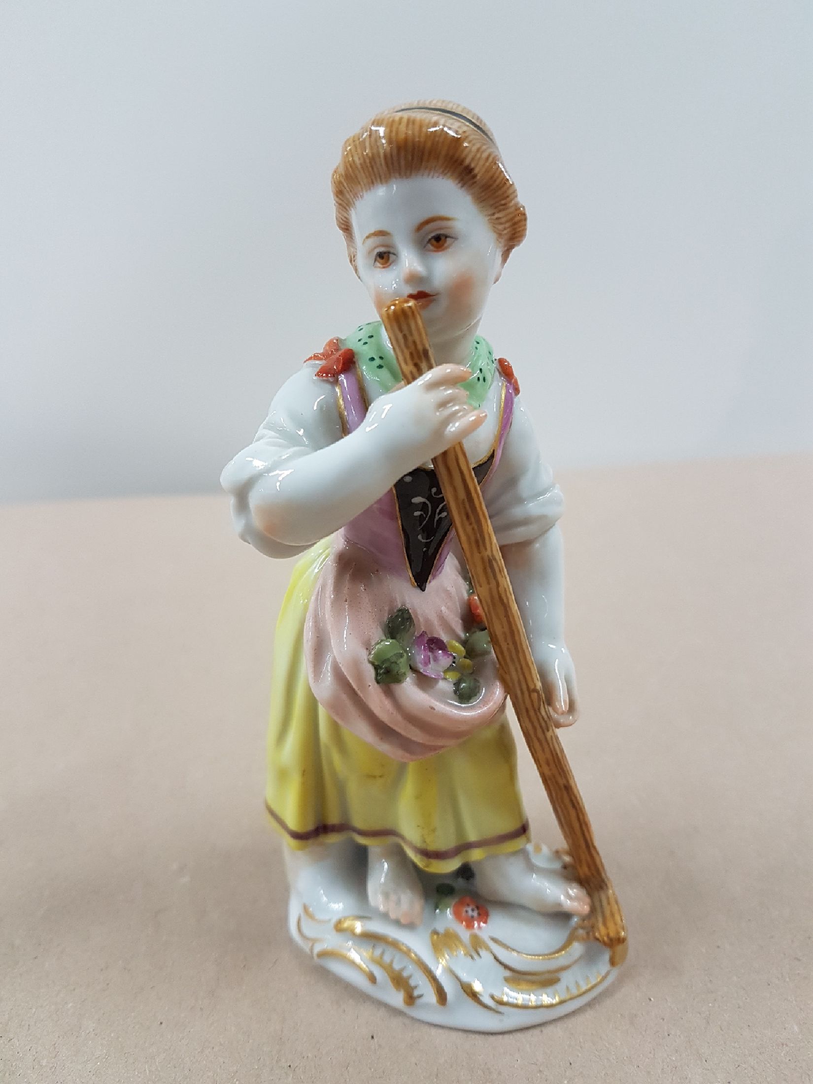Detail a: Porzellanfigur, Meissen, wohl 60er Jahre, Gärtnerin mit Rechen, polychrom bemalt, Goldstaffage, H. 12.5 cm