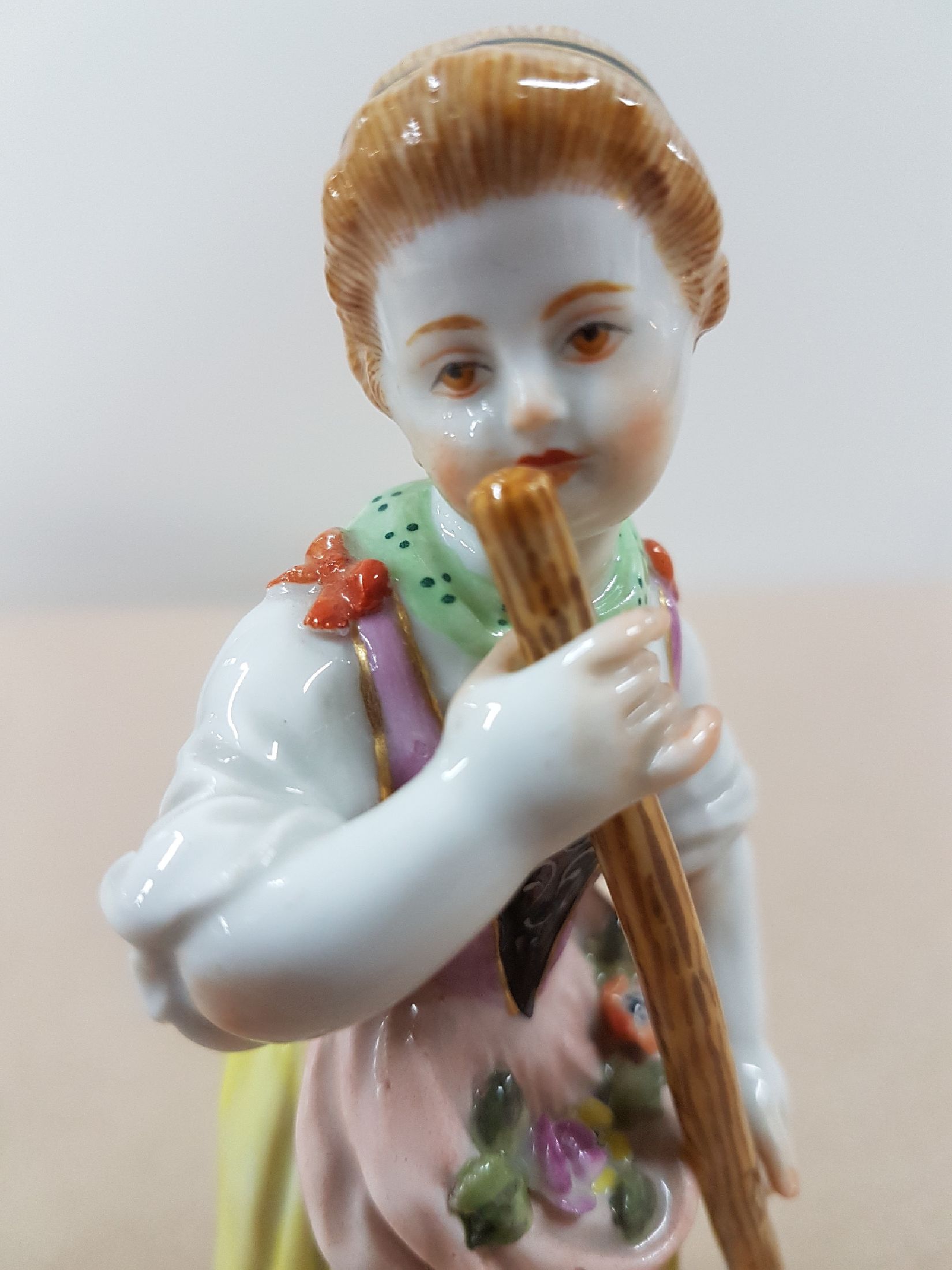 Detail e: Porzellanfigur, Meissen, wohl 60er Jahre, Gärtnerin mit Rechen, polychrom bemalt, Goldstaffage, H. 12.5 cm