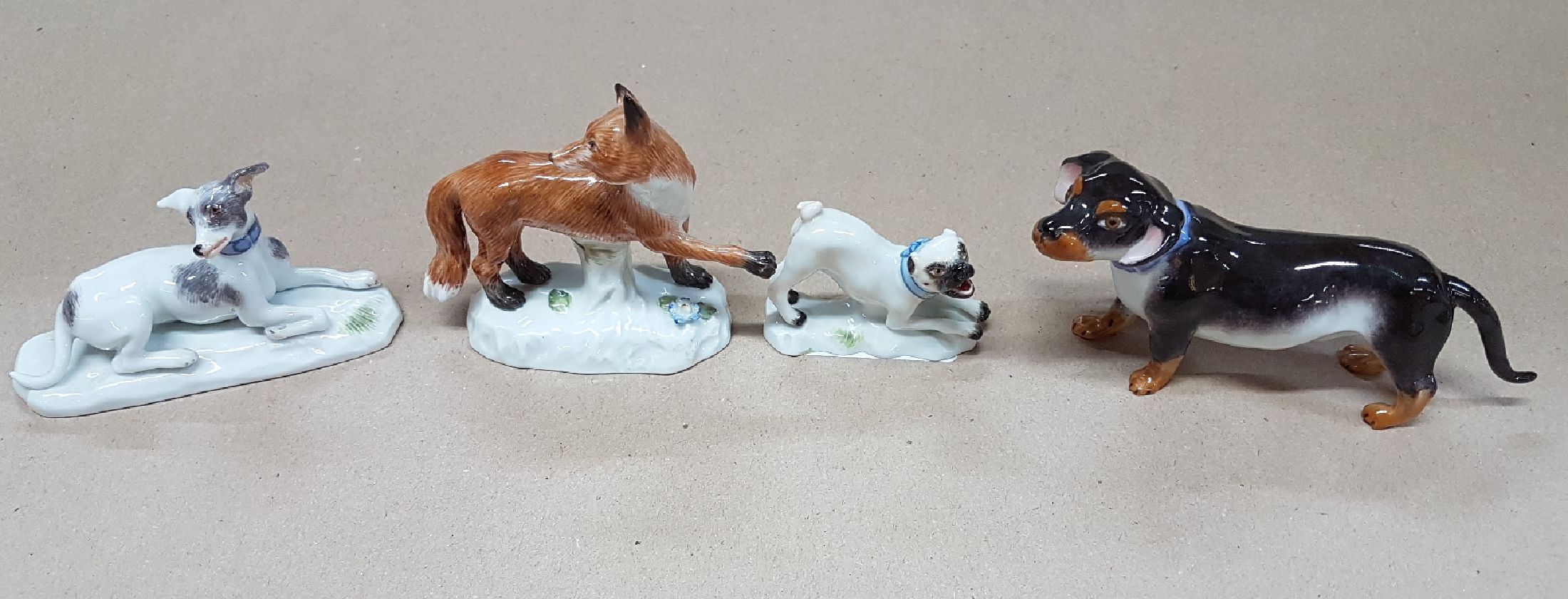 Detail a: Vier Miniaturen/Porzellanfiguren, Meissen, 20. Jh., Tierdarstellungen, feine polychrome Bemalung, Fuchs L. 7 cm, Dackel L. 10 cm, liegender Jagdhund, ...