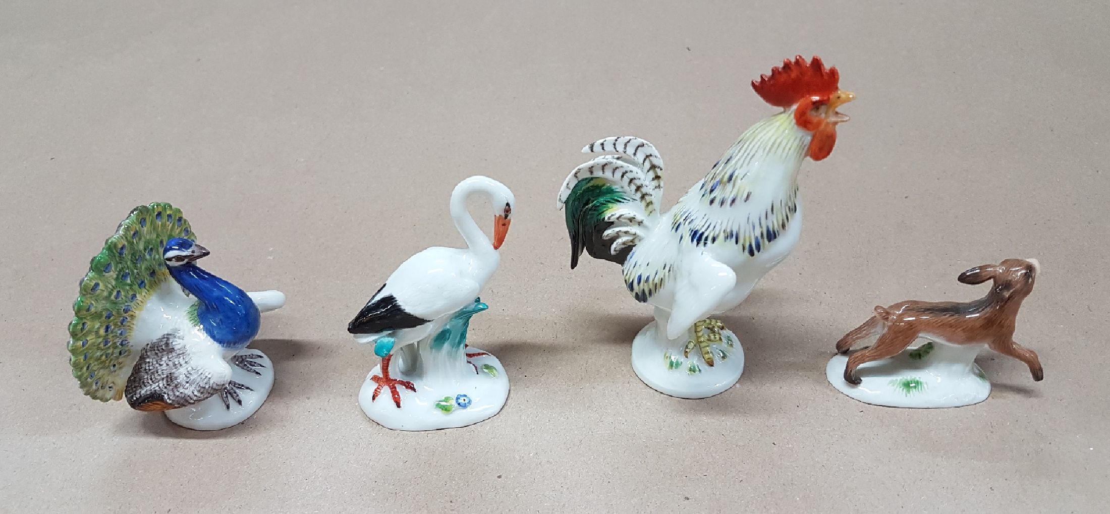 Detail b: Vier Miniaturen/Figuren, Meissen, 20. Jh., Tierfiguren, polychrom bemalt, Hahn H. 9cm, 4x5cm. Pfau H. 5.3 cm; Storch ca. 6.2 cm