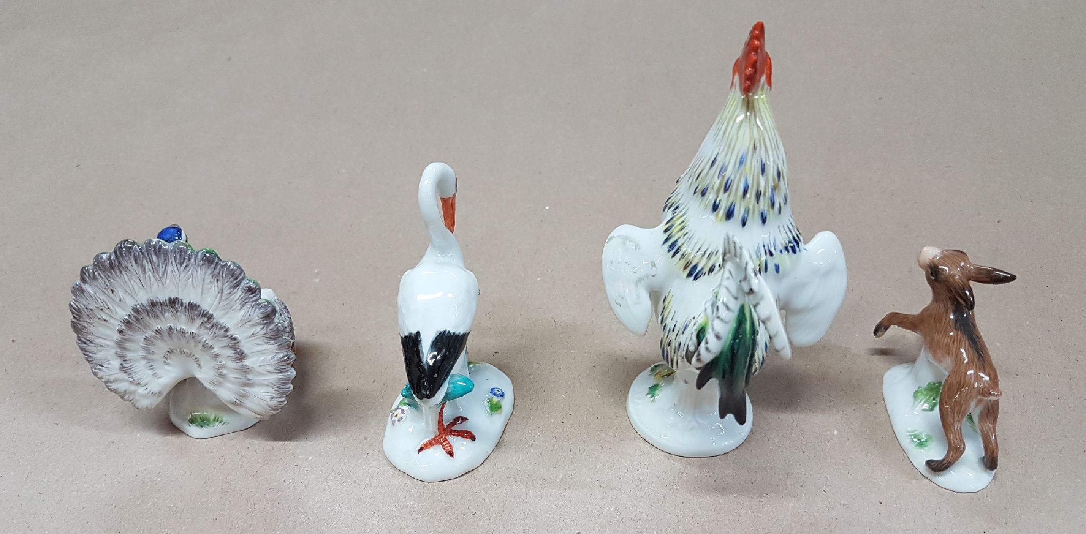 Detail c: Vier Miniaturen/Figuren, Meissen, 20. Jh., Tierfiguren, polychrom bemalt, Hahn H. 9cm, 4x5cm. Pfau H. 5.3 cm; Storch ca. 6.2 cm