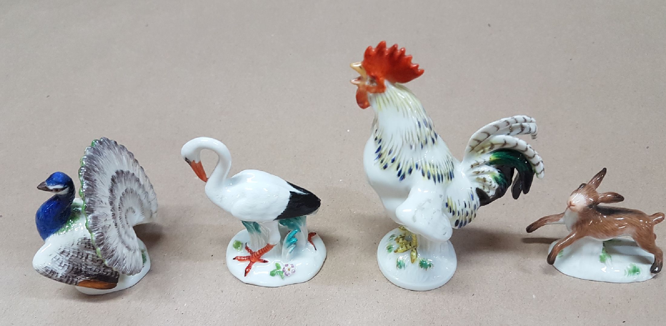 Detail d: Vier Miniaturen/Figuren, Meissen, 20. Jh., Tierfiguren, polychrom bemalt, Hahn H. 9cm, 4x5cm. Pfau H. 5.3 cm; Storch ca. 6.2 cm