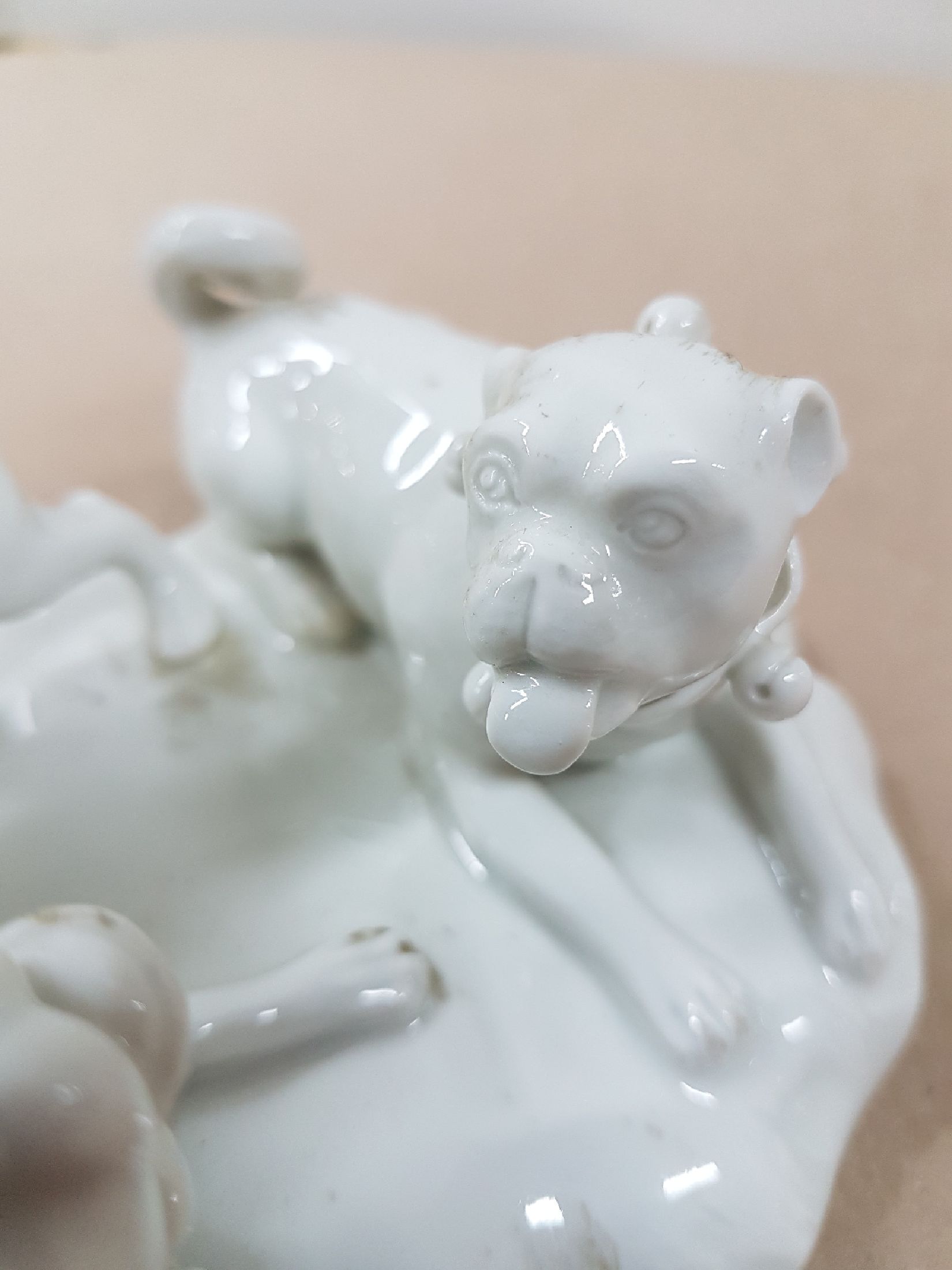 Detail f: Porzellangruppe, Meissen, 20. Jh., weiß, drei spielende Möpse, Entwurf August Ringler, Modellnr. 78836, zwei Schleifstriche,8.5 x 16 x 10 cm, ...