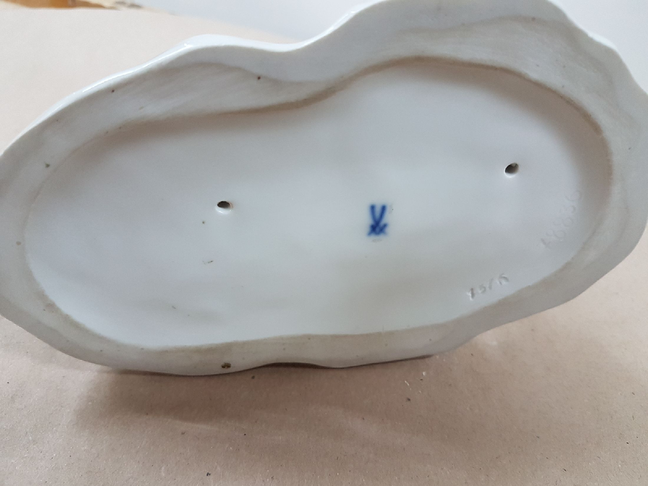 Detail g: Porzellangruppe, Meissen, 20. Jh., weiß, drei spielende Möpse, Entwurf August Ringler, Modellnr. 78836, zwei Schleifstriche,8.5 x 16 x 10 cm, ...