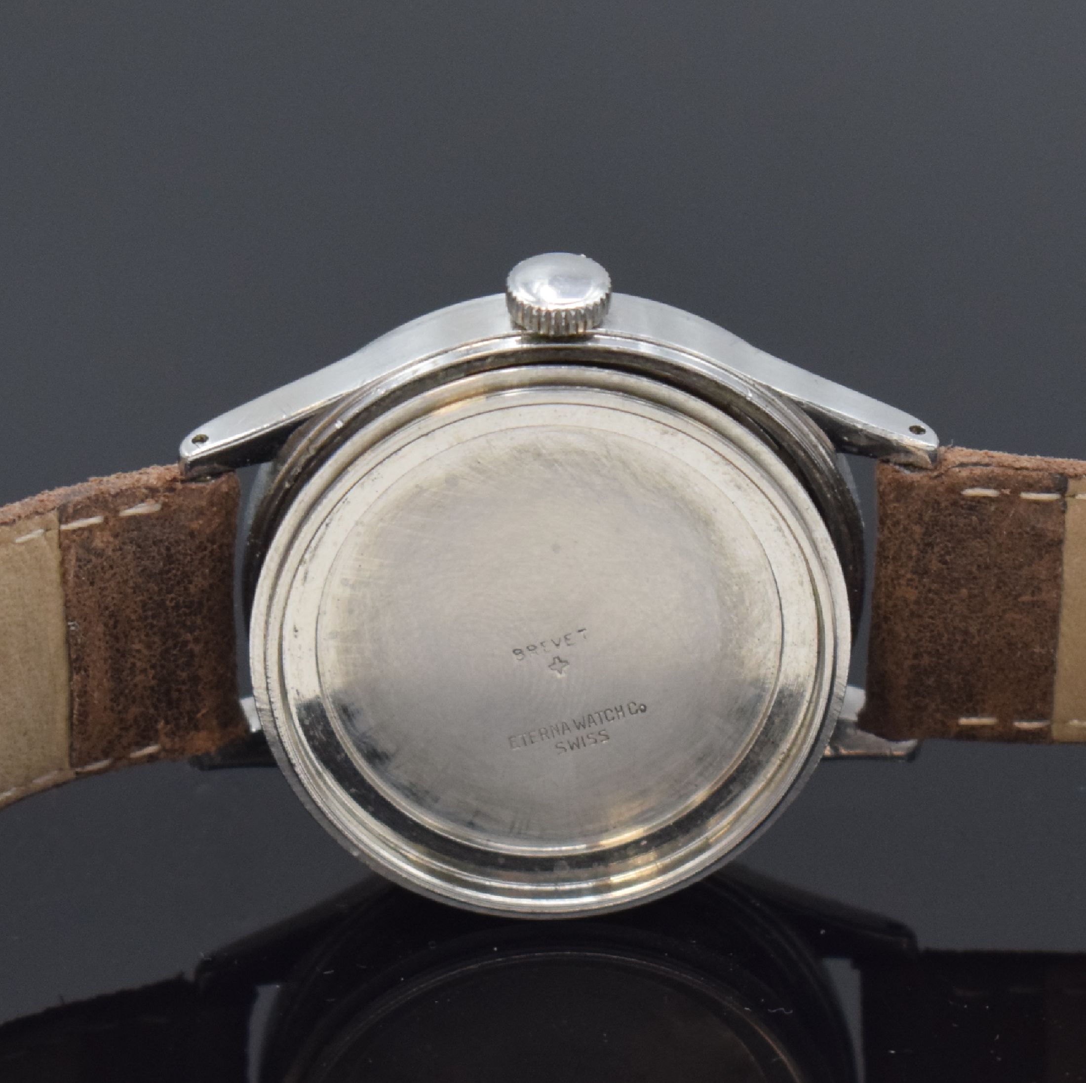 Detail e: ETERNA seltene große Herrenarmbanduhr in Stahl, Schweiz um 1950, Handaufzug, verschr. Geh., silb. Zifferbl. pat., röm. Leucht- zahlen, gold. ...