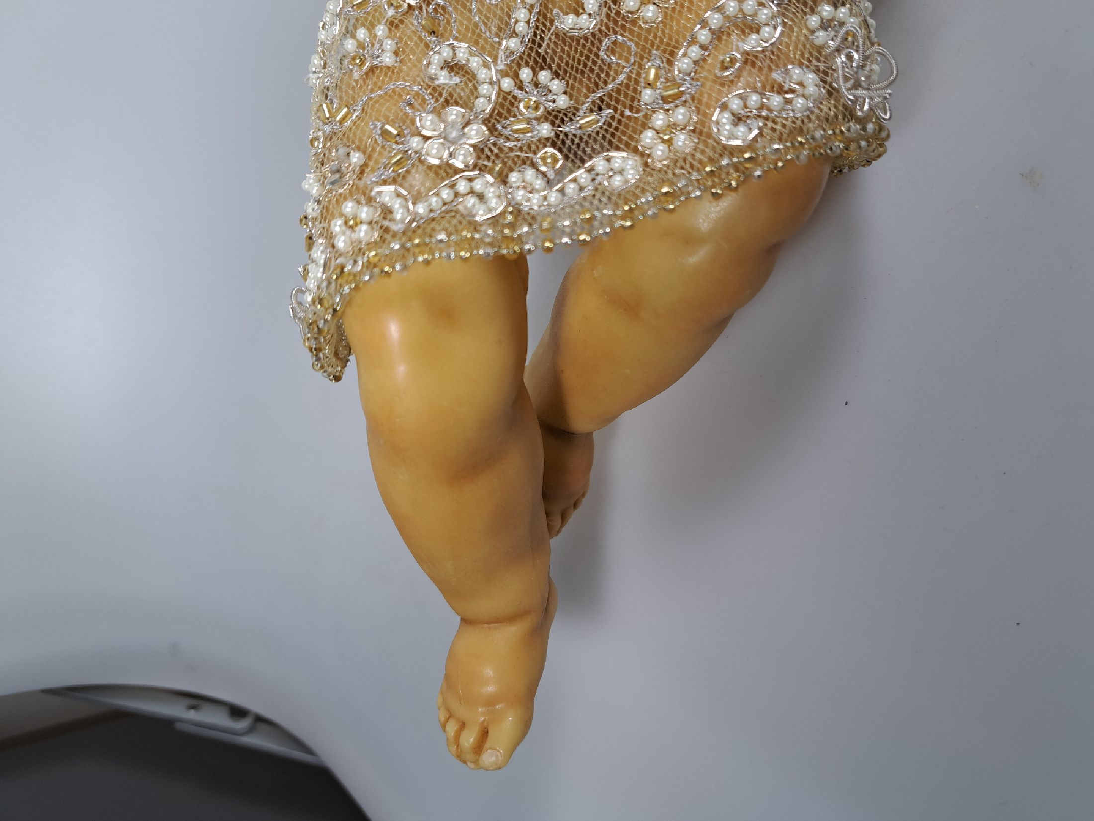 Detail c: Fatschenkind im Glasschrein, süddeutsch, 20.Jh., Wachskorpus wohl 19.Jh., Bekleidung und Auskleidung mit Spitzenbesatz und Goldbrokatstickerei, ...