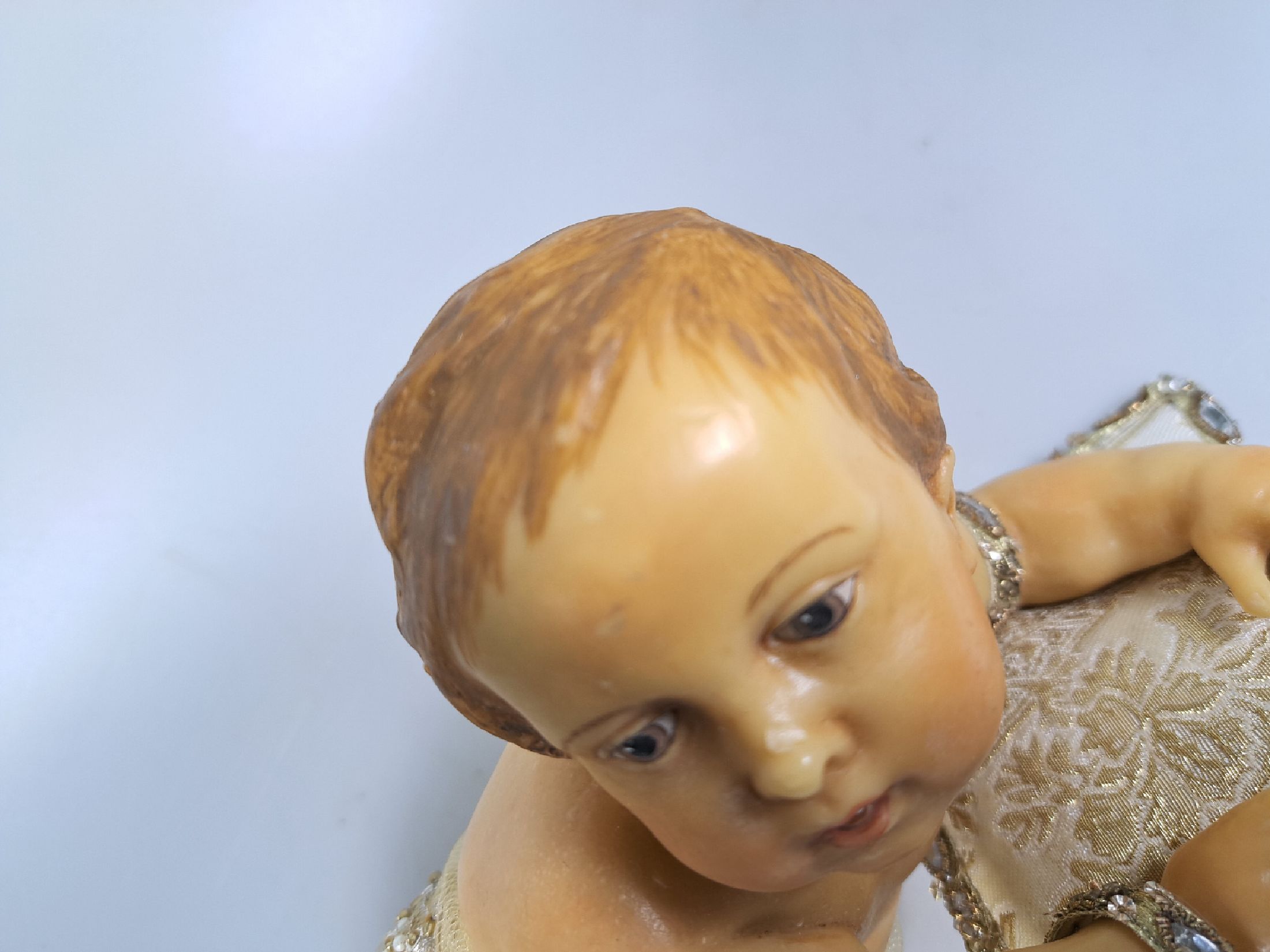 Detail d: Fatschenkind im Glasschrein, süddeutsch, 20.Jh., Wachskorpus wohl 19.Jh., Bekleidung und Auskleidung mit Spitzenbesatz und Goldbrokatstickerei, ...