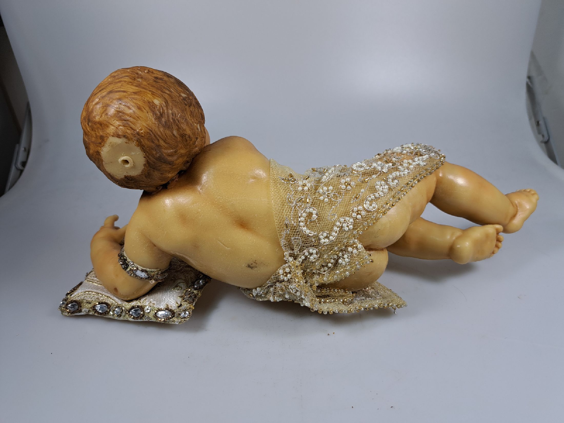Detail e: Fatschenkind im Glasschrein, süddeutsch, 20.Jh., Wachskorpus wohl 19.Jh., Bekleidung und Auskleidung mit Spitzenbesatz und Goldbrokatstickerei, ...