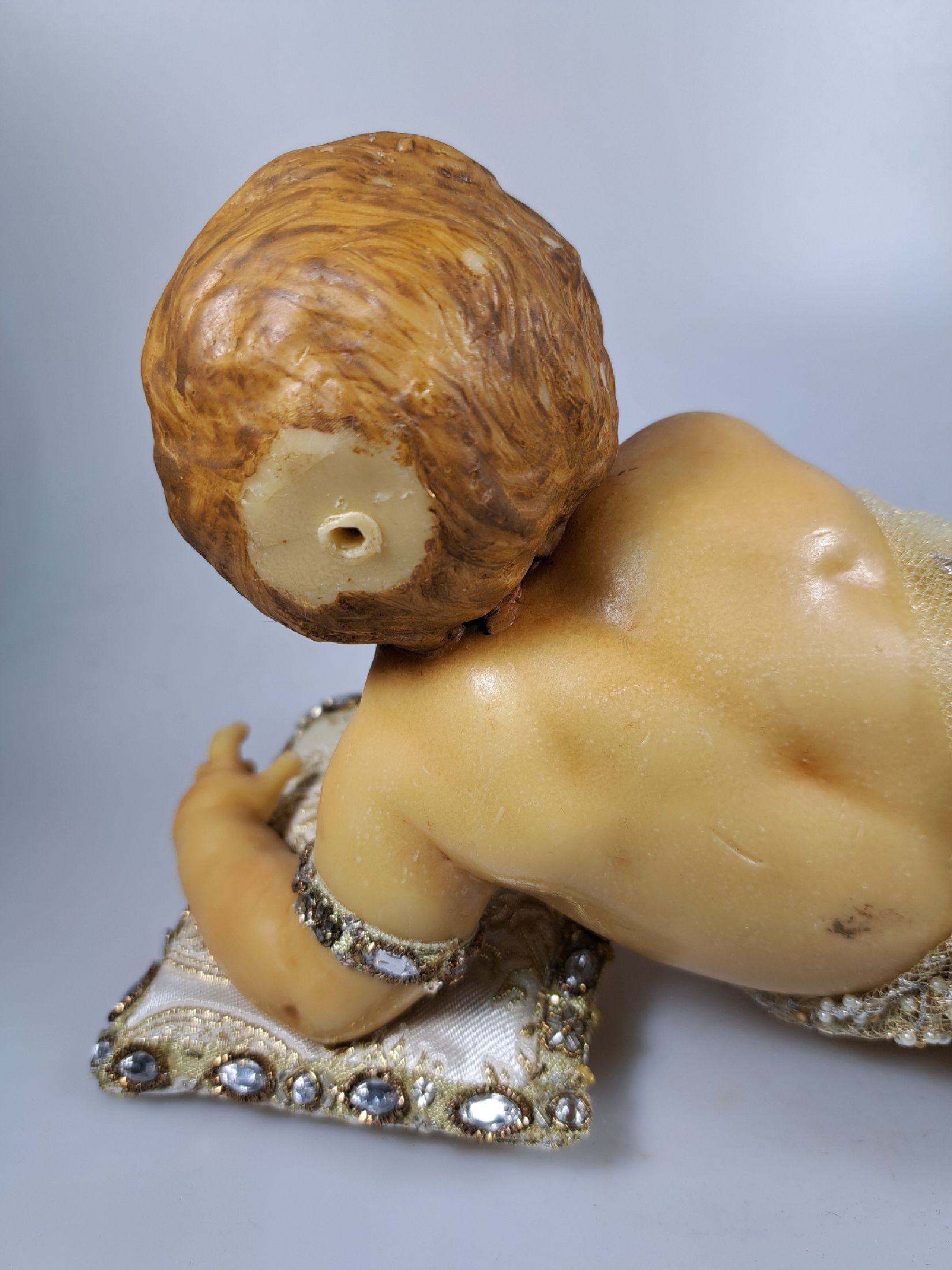 Detail h: Fatschenkind im Glasschrein, süddeutsch, 20.Jh., Wachskorpus wohl 19.Jh., Bekleidung und Auskleidung mit Spitzenbesatz und Goldbrokatstickerei, ...