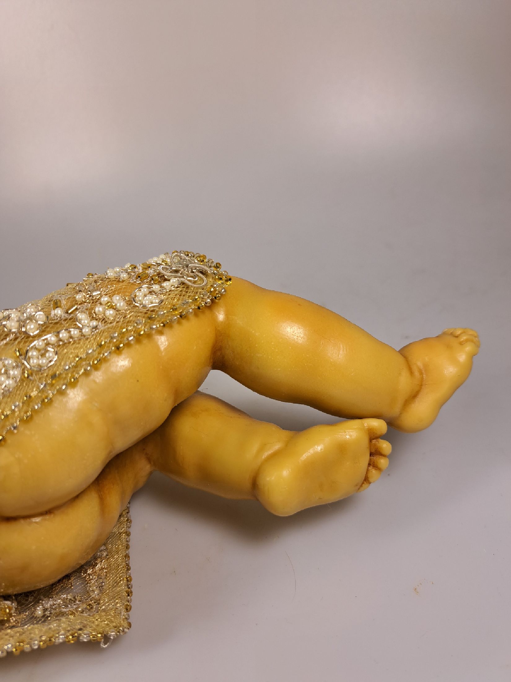 Detail j: Fatschenkind im Glasschrein, süddeutsch, 20.Jh., Wachskorpus wohl 19.Jh., Bekleidung und Auskleidung mit Spitzenbesatz und Goldbrokatstickerei, ...