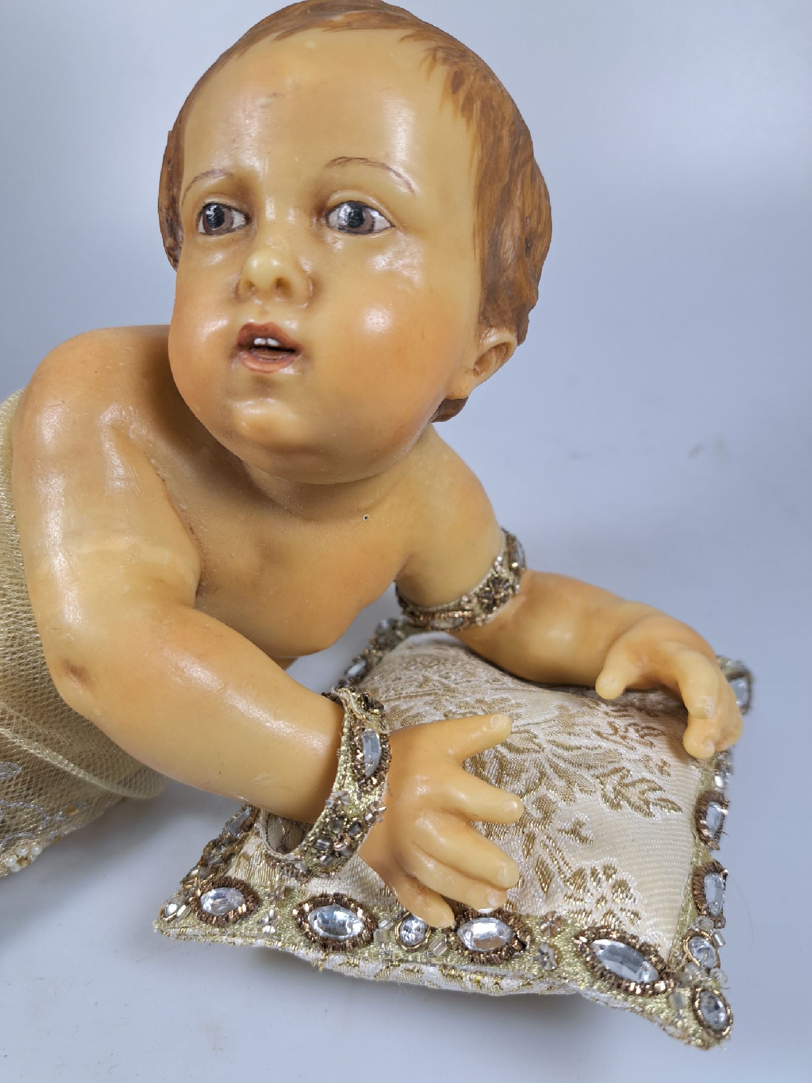 Detail k: Fatschenkind im Glasschrein, süddeutsch, 20.Jh., Wachskorpus wohl 19.Jh., Bekleidung und Auskleidung mit Spitzenbesatz und Goldbrokatstickerei, ...