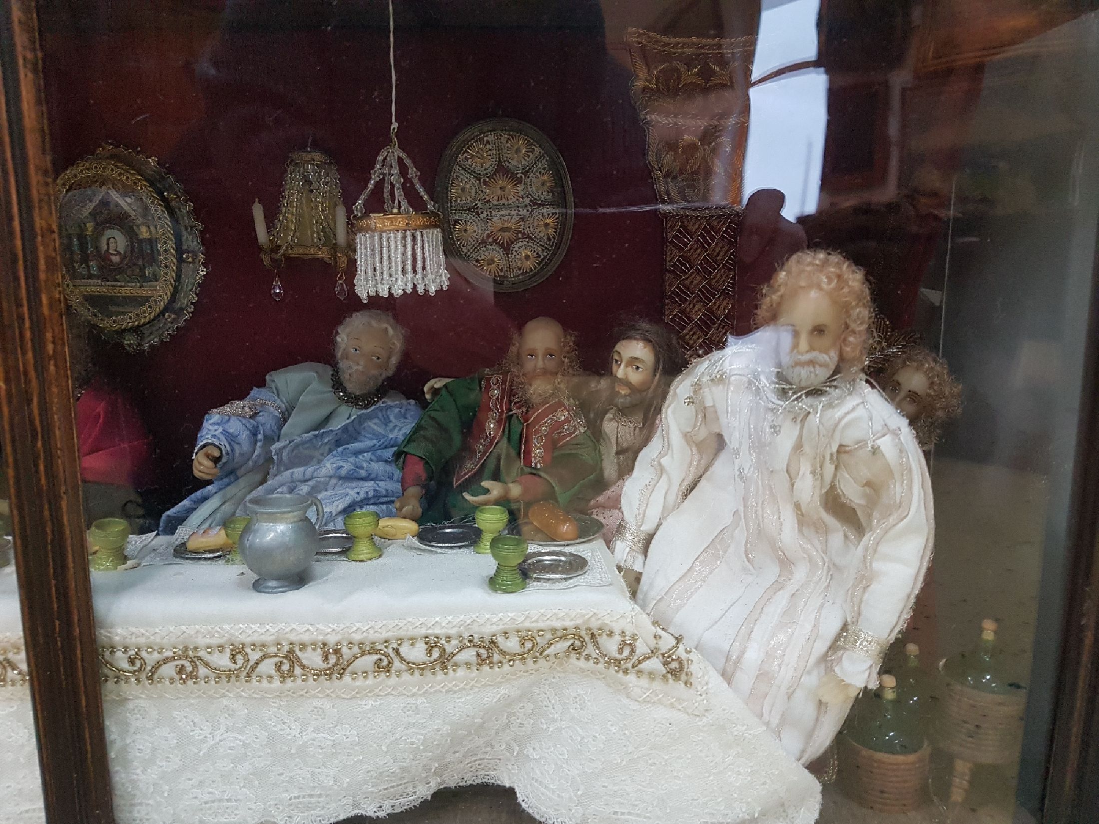 Detail a: Großes Eingericht: Das letzte Abendmahl, 20.Jh., dreiseitig verglaster Schrein, 13 Wachsfiguren, Bekleidung und Einrichtung mit Spitzenbesatz und ...