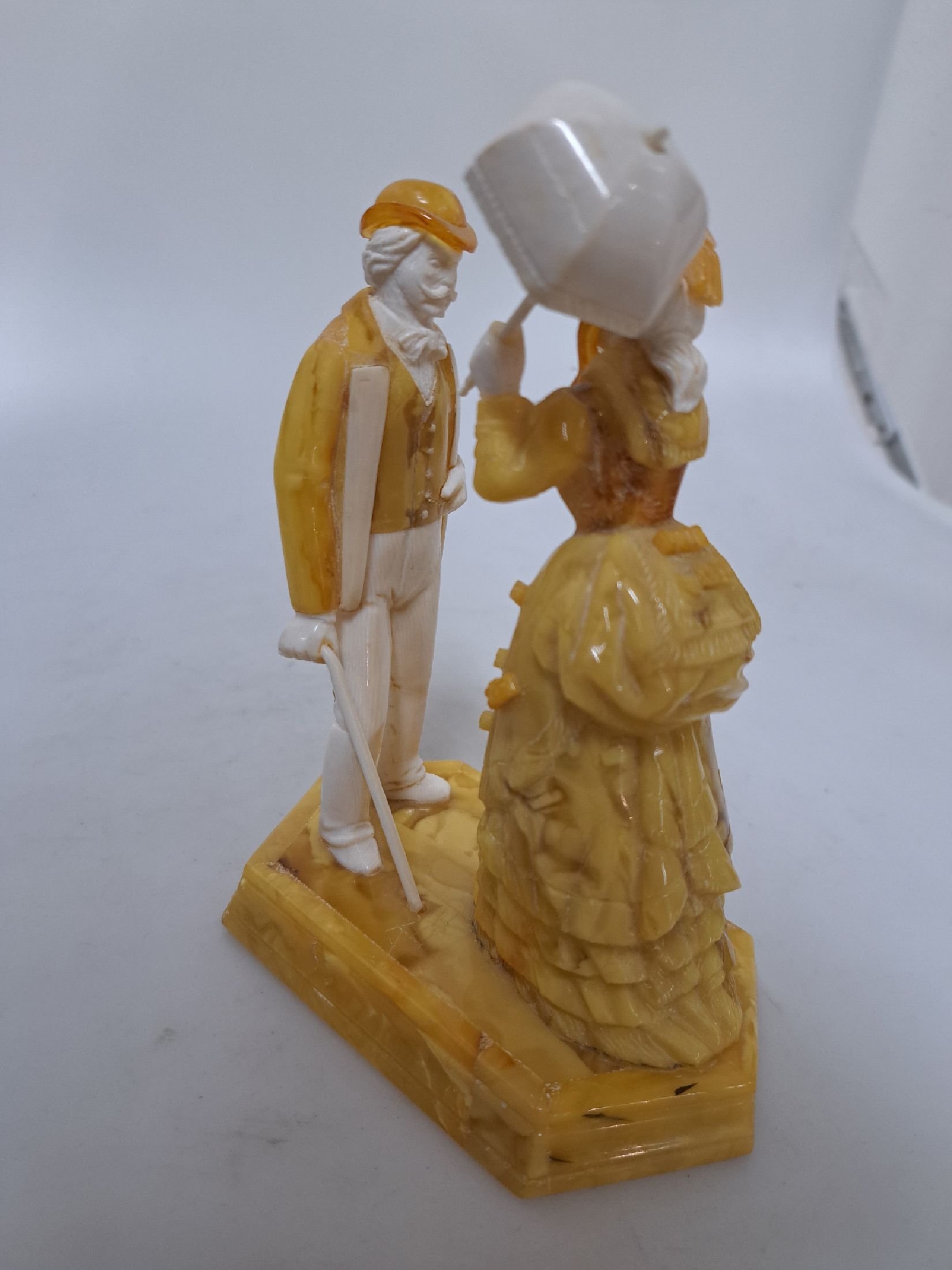 Detail e: Alfred Schlegge, 1923-2015, Figurengruppe, elegantes Paar aus Bernstein und Elfenbein, fein geschnitzt, auf sechseckigem Sockel stehende Paar, dame ...