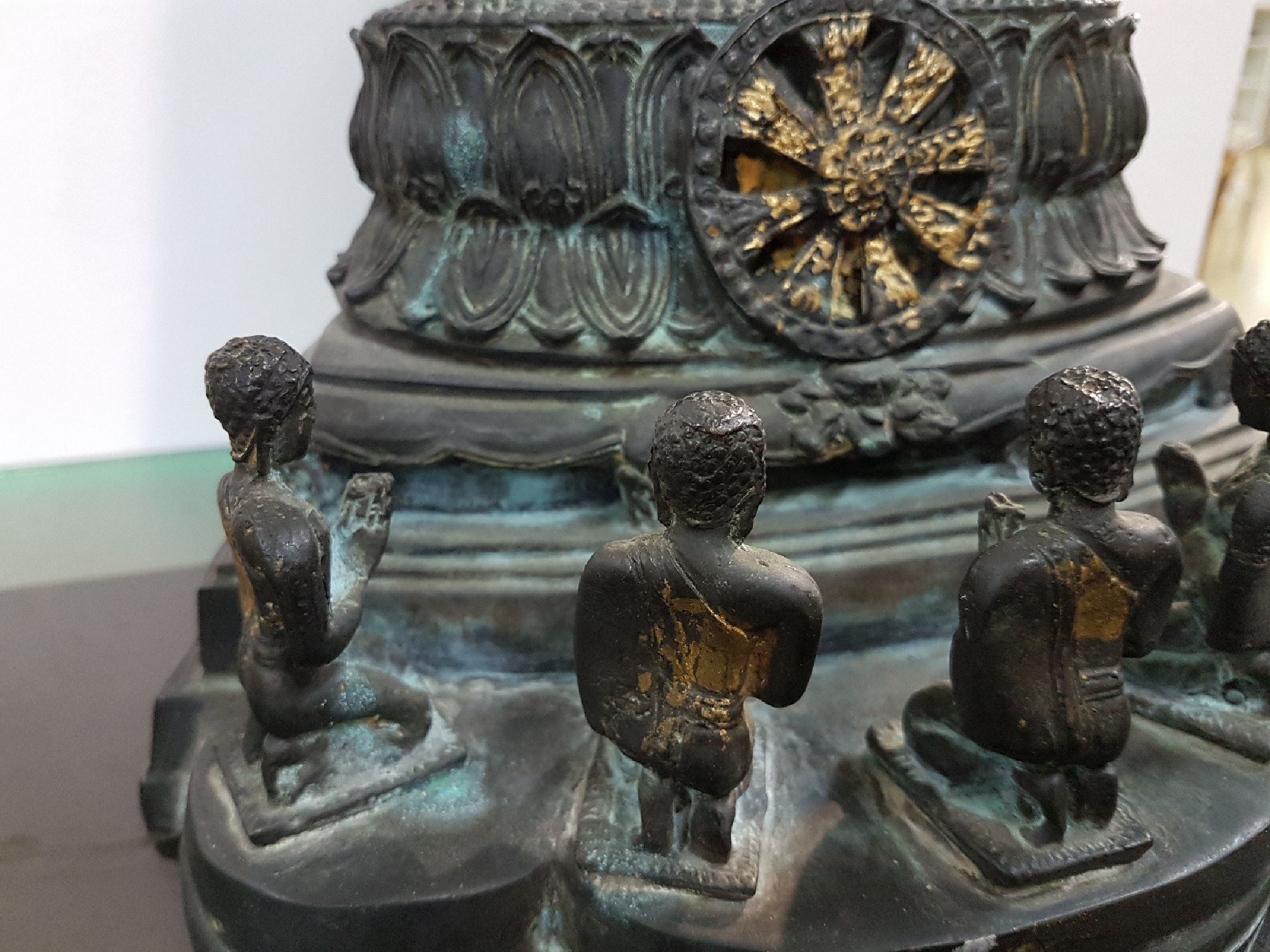 Detail d: Buddha, Burma, 20.Jh., Bronze, im Dhyana Mudra im vollen Lotussitz auf einem hohen getreppten Lotusthron sitzend, darunter Rad der Lehre und fünf ...