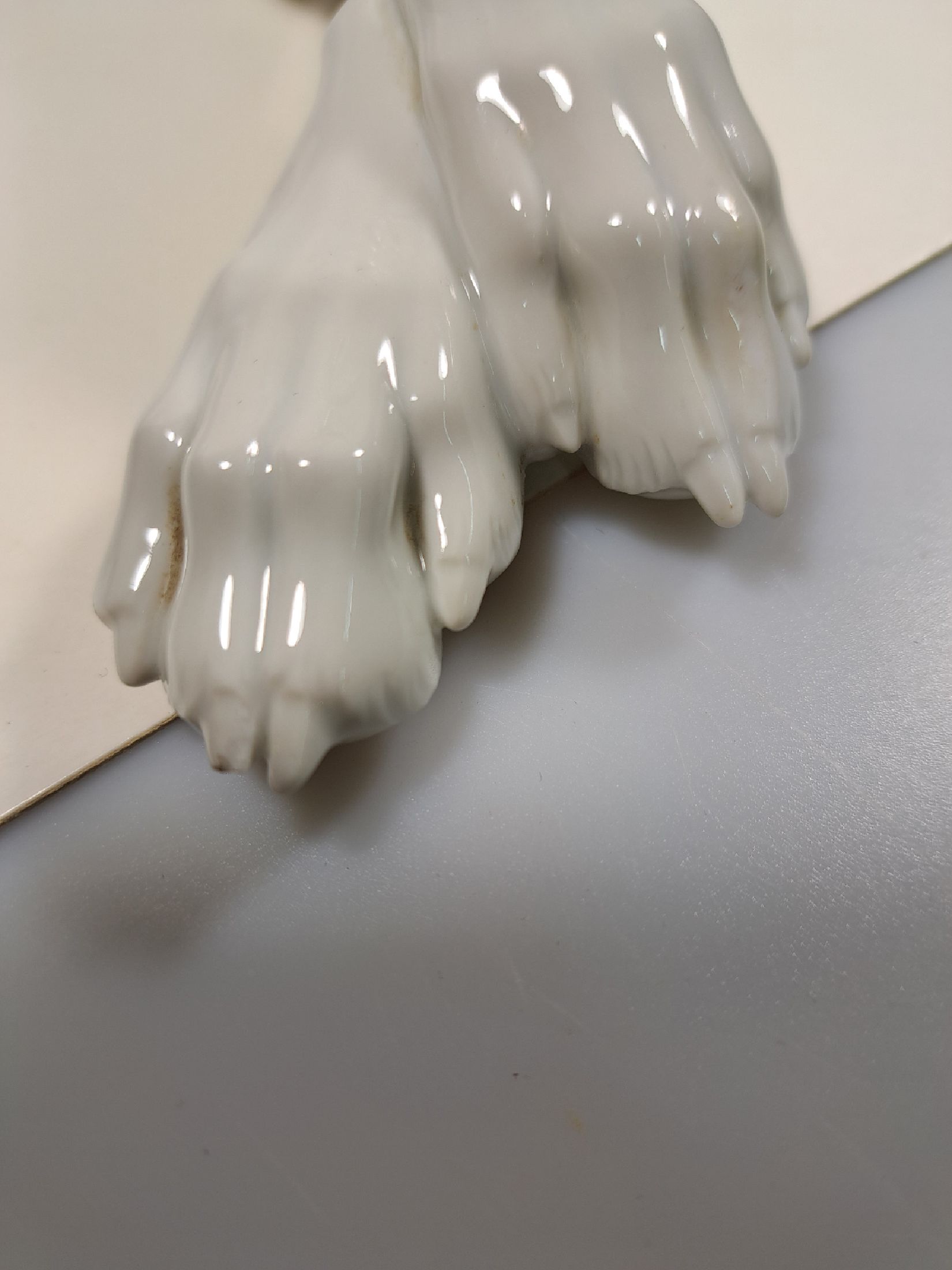 Detail g: Große Porzellanfigur, Allach, 1940er Jahre, liegender Schäferhund, weiß, Entwurf Theodor Kärner, sign., Blindmarke, Krallenspitze am Vorderlauf ...