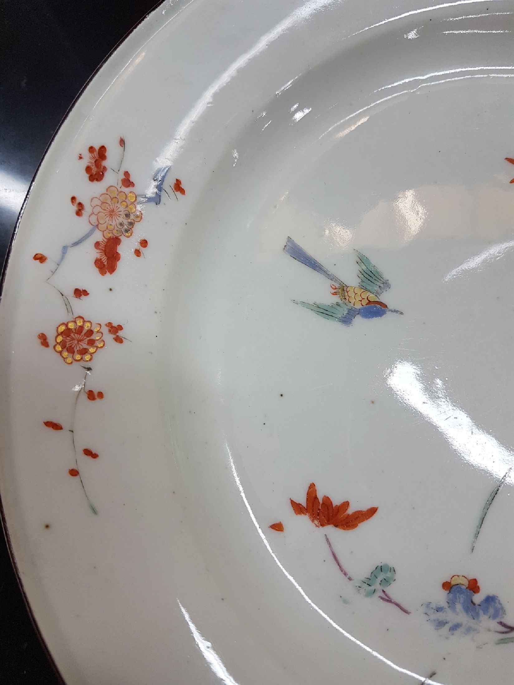 Detail d: Früher Teller, Meissen, um 1730, Kakiemondekor, Fels- und Vogel, feine polychrome Bemalung, brauner Rand, altersbedingt berieben, D.23 cm
