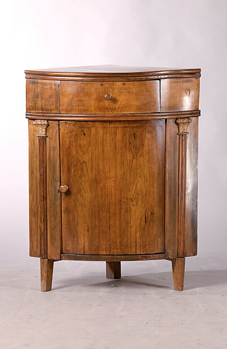 Kleiner Eckschrank, 1810, Nußbaumfurnier, eintüriger Korpus mit einer Schublade, mit vergoldeten Kapitellen, spitze Füße ergänzt, ca. 92 x 72 x ...