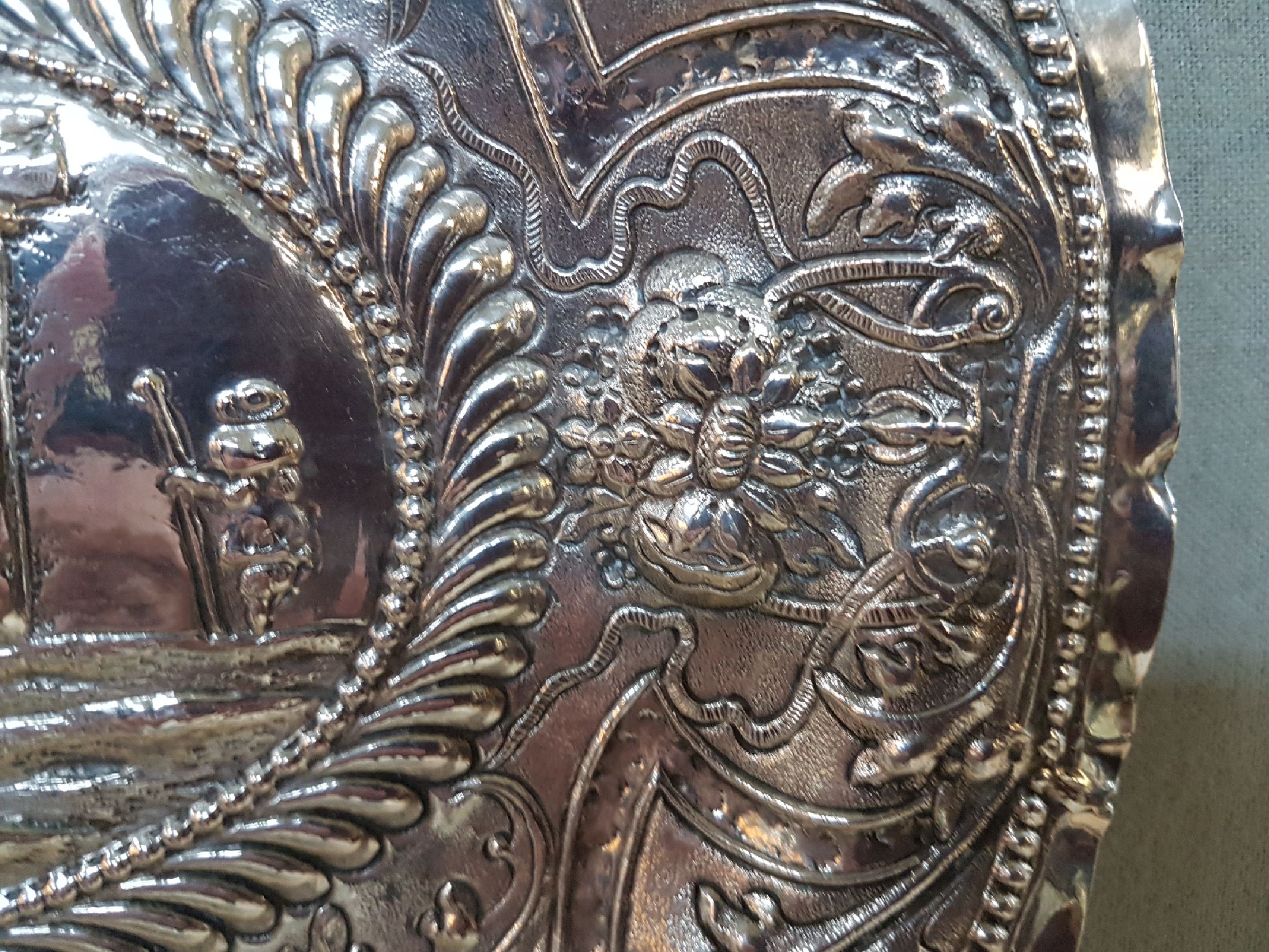 Detail b: Prunkplatte, Hamburg, 18. Jh., Silber, im Spiegel Ruinenlandschaft mit Schäfer, Fahne mit Bandelwerk und Blumen, Rand gekniffen, am Rand bez. ...