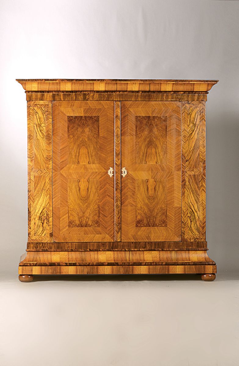 Barockschrank, um 1770/1780, Nußbaumfurnier gespiegelt verlegt, Rahmenfüllungen aus Wurzelnuss, zweitürig, orig. Messingbeschläge, ...