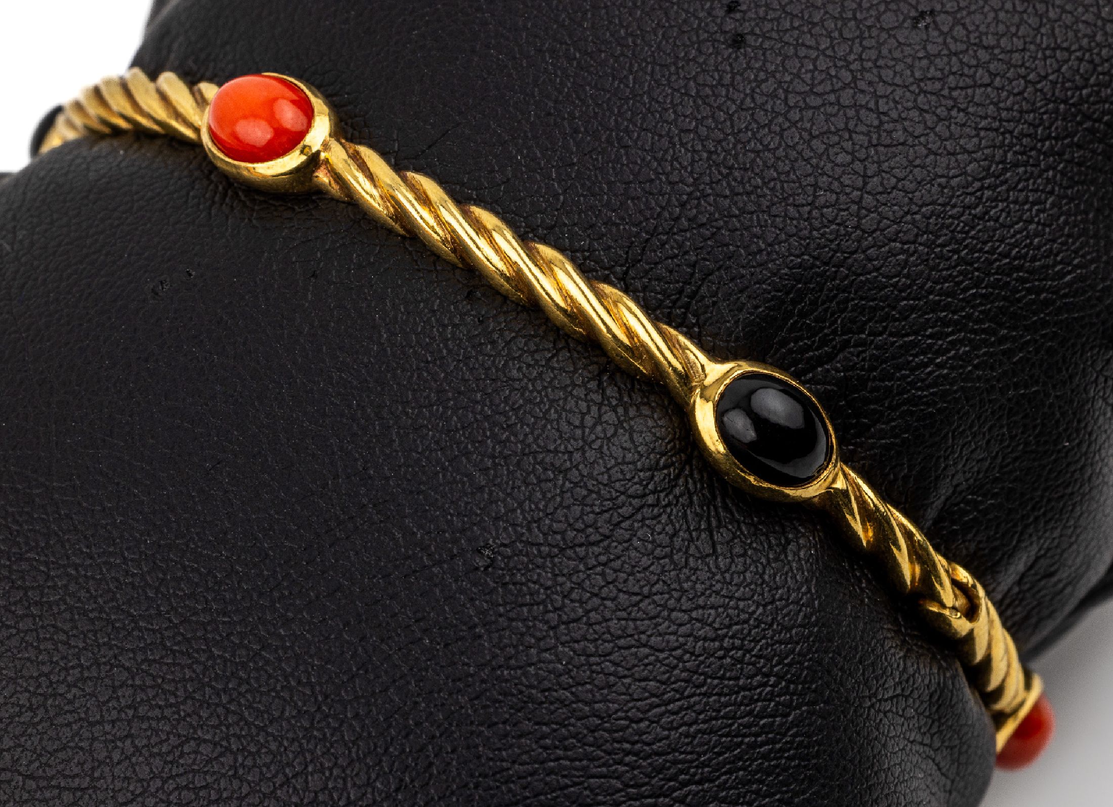 18 kt Gold Korallen-Onyx-Armreif, GG 750/000, 3 ovale Korallen- und Onyxcabochons, D. ca. 6 cm, Kastenschloß mit Sicherheitsacht,ca. 13.6 g, ...