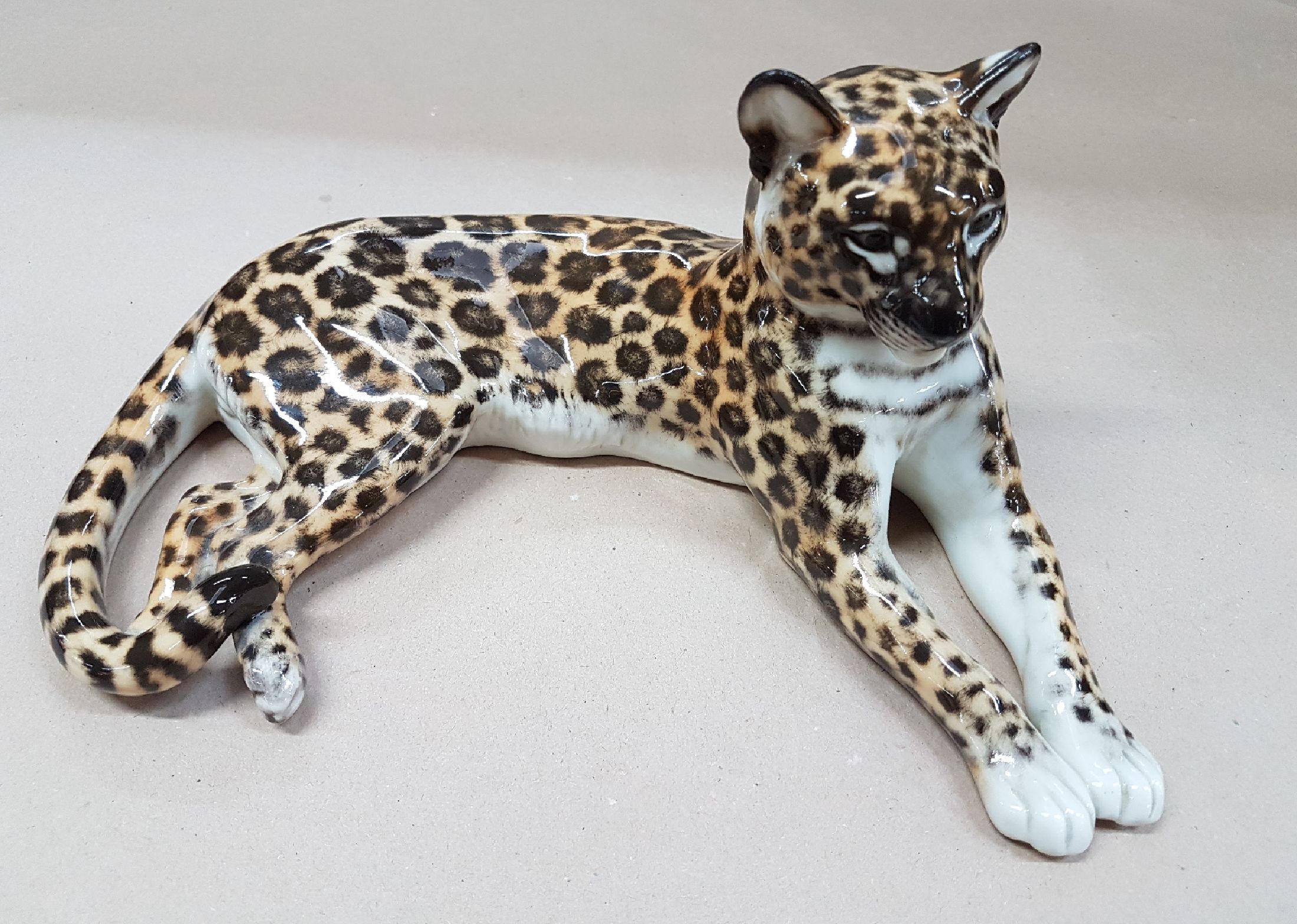 Detail a: Porzellanfigur liegender Leopard, Nymphenburg, Entw. Theodor Kärner, 2.Hälfte 20.Jh., Porzellan, naturalistisch bemalt, Modellnr. 153, Alterssp., ...