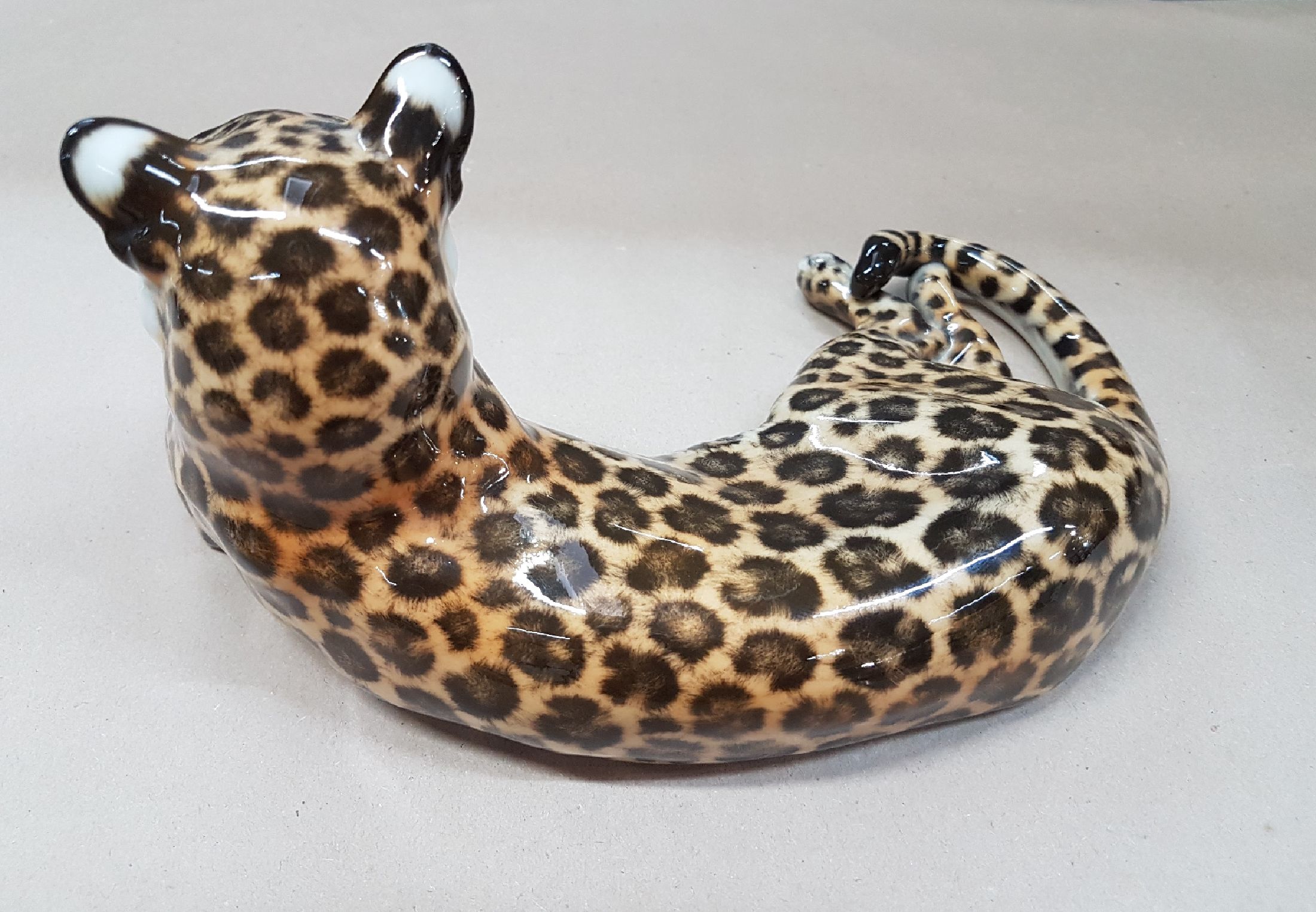 Detail b: Porzellanfigur liegender Leopard, Nymphenburg, Entw. Theodor Kärner, 2.Hälfte 20.Jh., Porzellan, naturalistisch bemalt, Modellnr. 153, Alterssp., ...