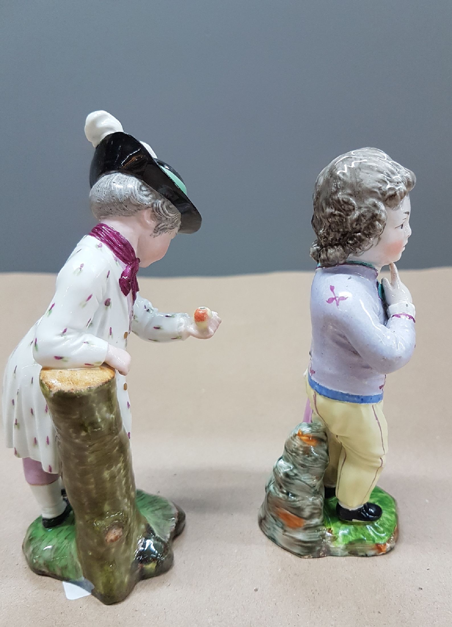 Detail b: Zwei Figuren, Entwurf J.P. Melchior, Höchst, Knabe mit Birne, l. fachgerecht rest., H. ca. 12 cm und Damm, Knabe mit Regenschirm, Ritzmarke 214, ...