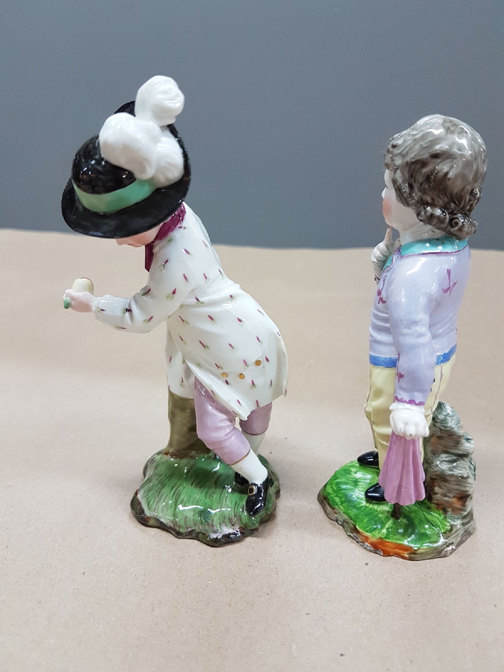 Detail d: Zwei Figuren, Entwurf J.P. Melchior, Höchst, Knabe mit Birne, l. fachgerecht rest., H. ca. 12 cm und Damm, Knabe mit Regenschirm, Ritzmarke 214, ...
