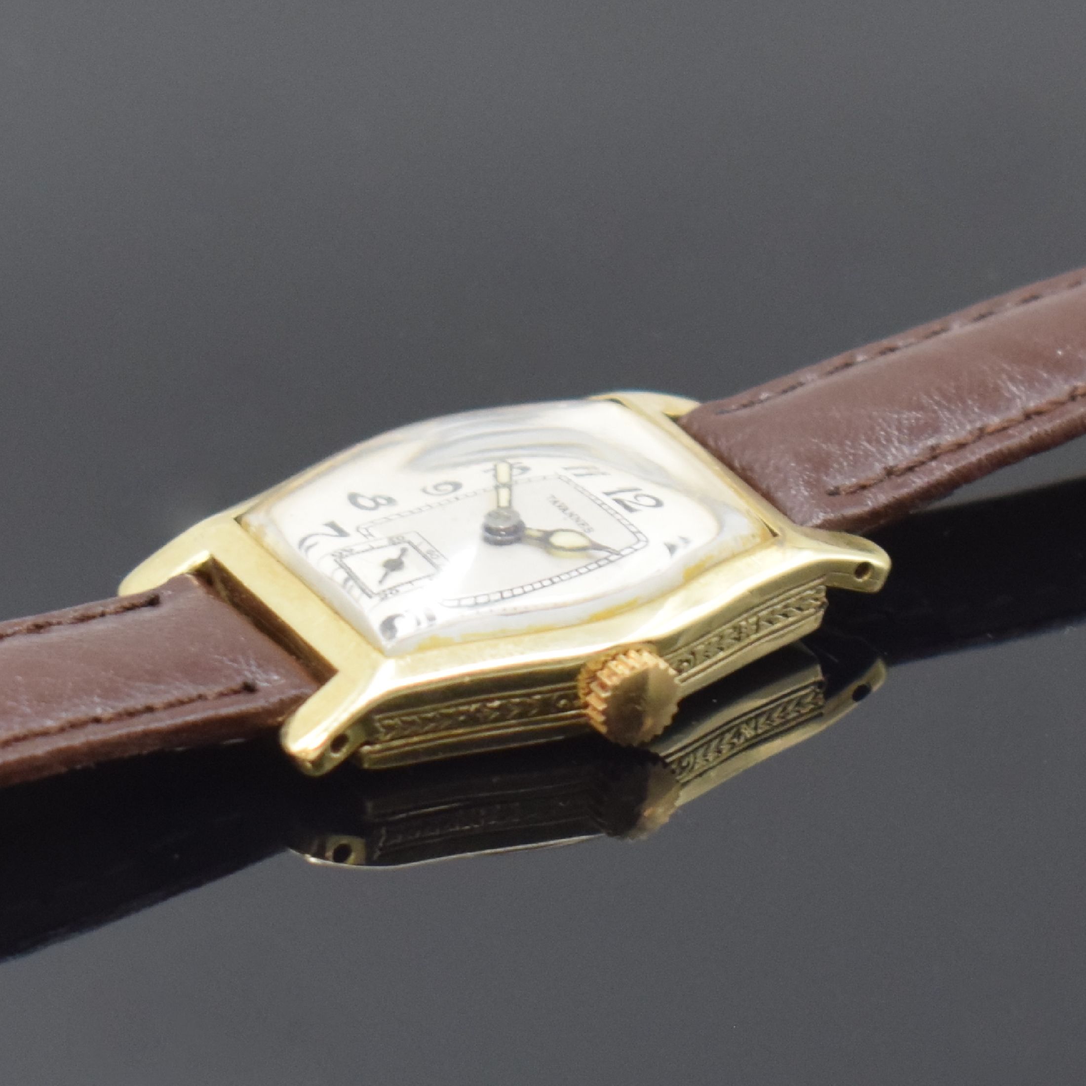 Detail b: TAVANNES Armbanduhr in GG 585/000, Schweiz um 1930, Handaufzug, seitl. grav. Geh. u. Scharnierboden dell., silb. Zifferbl. rest., arab. Zahlen, ...