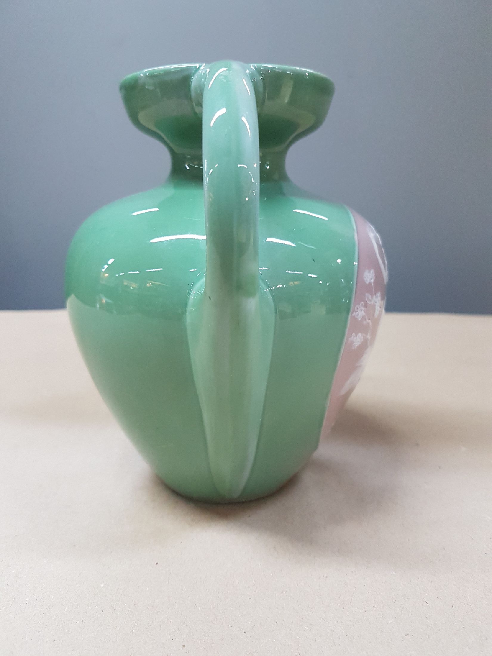 Detail b: Doppelhenkelvase, Frankreich, um 1900, Pate-sur-pate, grüner Fond, in grossem Medaillon Mädchendarstellung in blühendem Geäst, daneben Putto mit ...