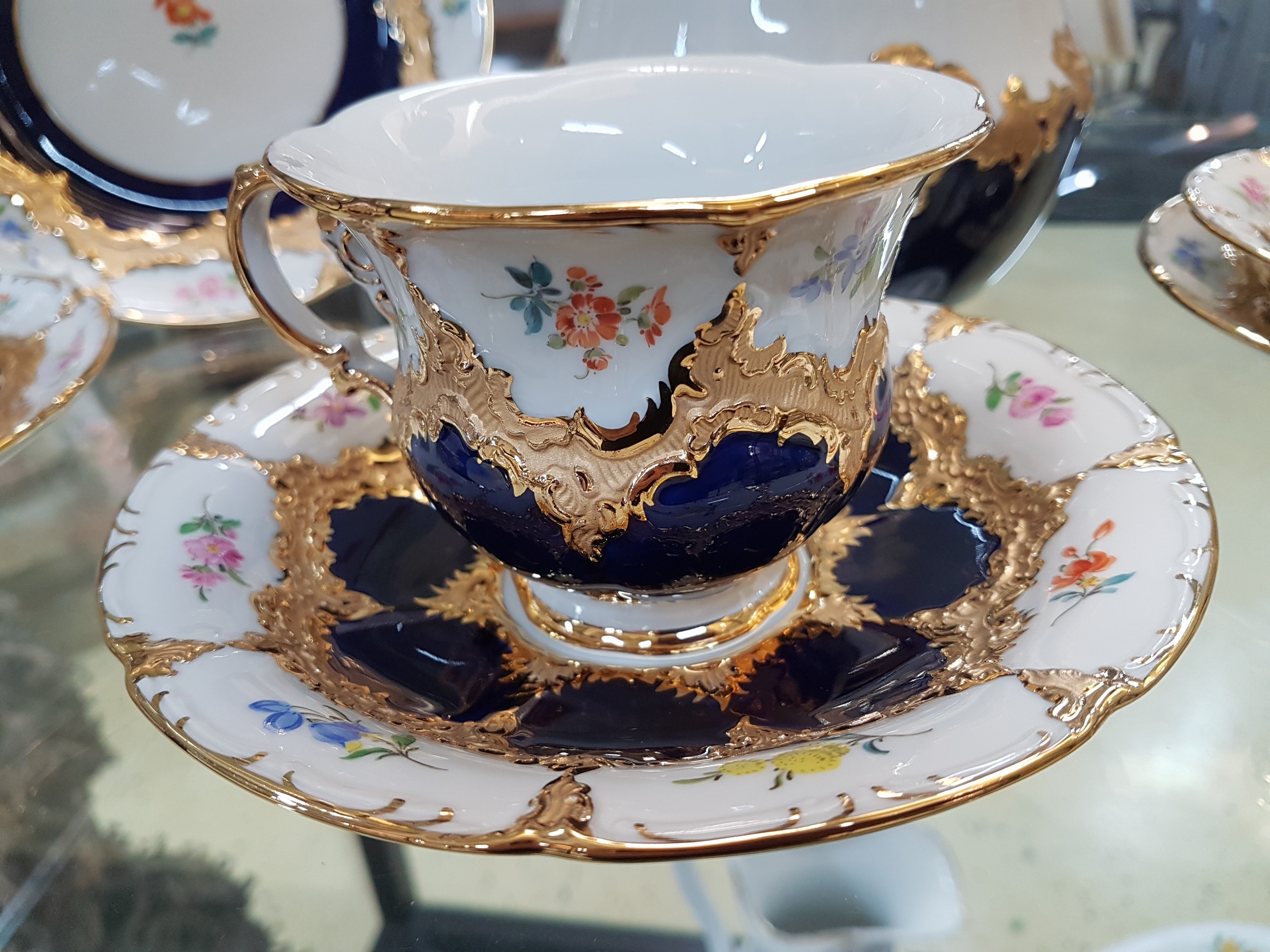 Detail a: Drei Gedecke u. grosse Bonboniere mit Deckel, Meissen, 2.H.20.Jh., B-Form, kobaltblau, Matt- u. Glanzgoldstaffage, davon zwei Gedecke 2. Wahl