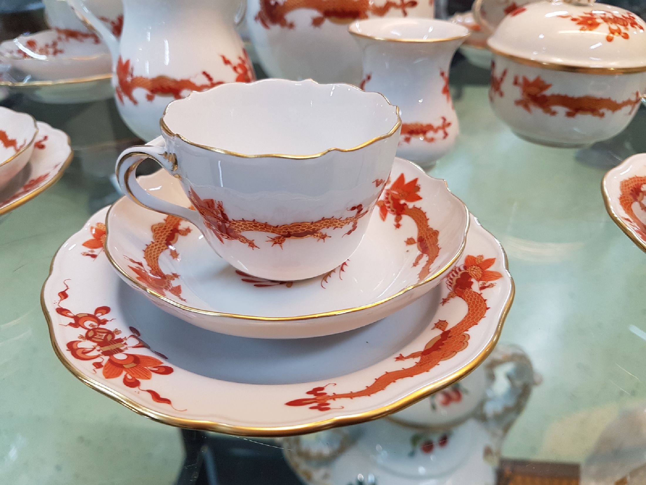 Detail b: Mokkaservice, Meissen, Roter Hofdrache, 2.H.20.Jh., goldgehöht: Mokkakanne, Zuckerdose u. Sahnegiesser, 7 Mokkatassen mit UT, 7 Gebäckteller, ...