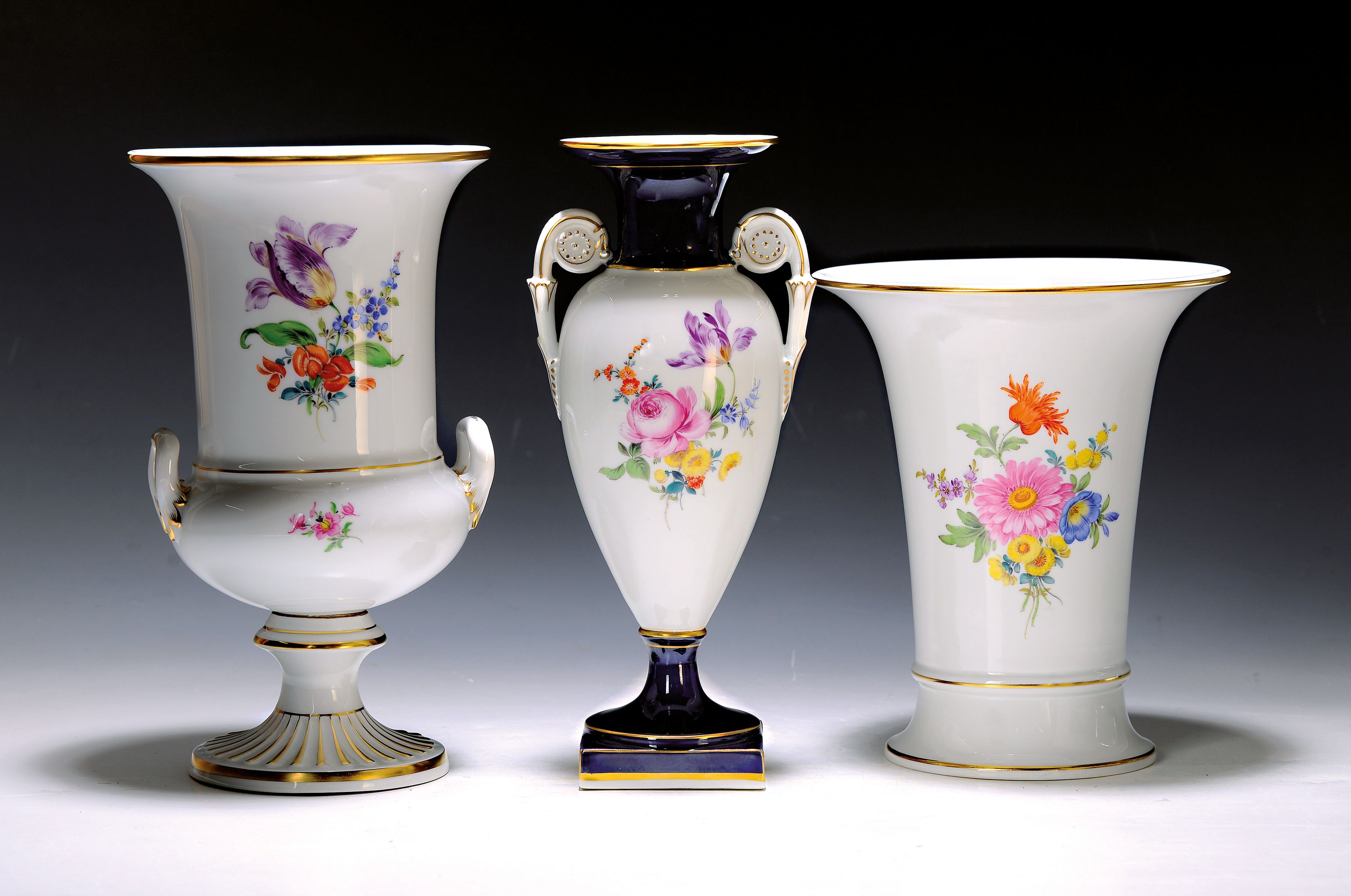 Drei Vasen Meissen, 2.H.20.Jh., 1. Wahl: Doppelhenkelvase, kobaltblau u. goldstaffiert, H.ca.25 cm; Doppelhenkelvase, H.ca. 24 cm, Trichtervase ca. ...