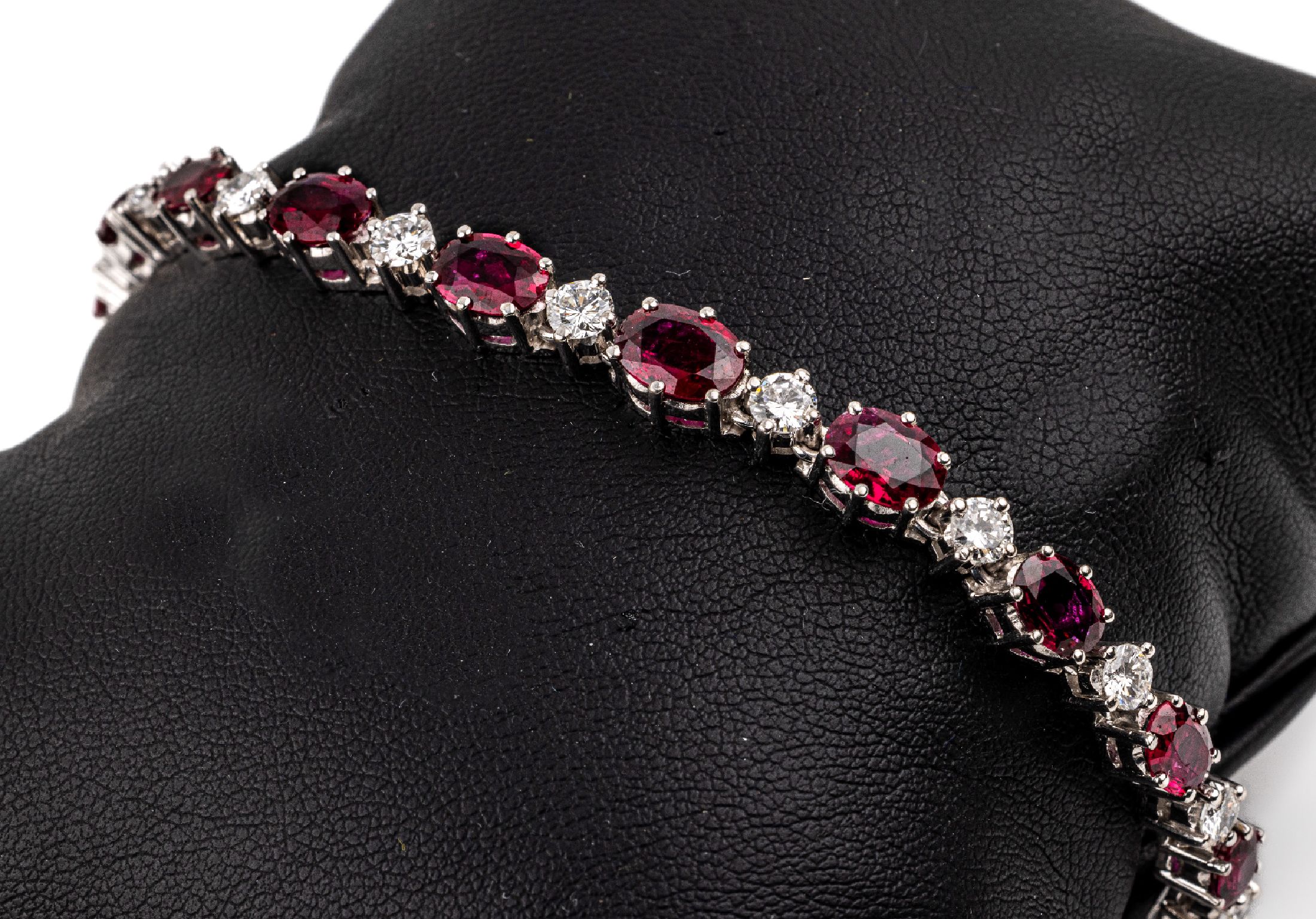 18 kt Gold Rubin-Brillant-Armband, WG 750/000, mit 17 ovalfacett. Rubinen von feinerFarbe zus. ca. 12.6 ct, leicht im Verlauf im Wechsel mit 17 ...