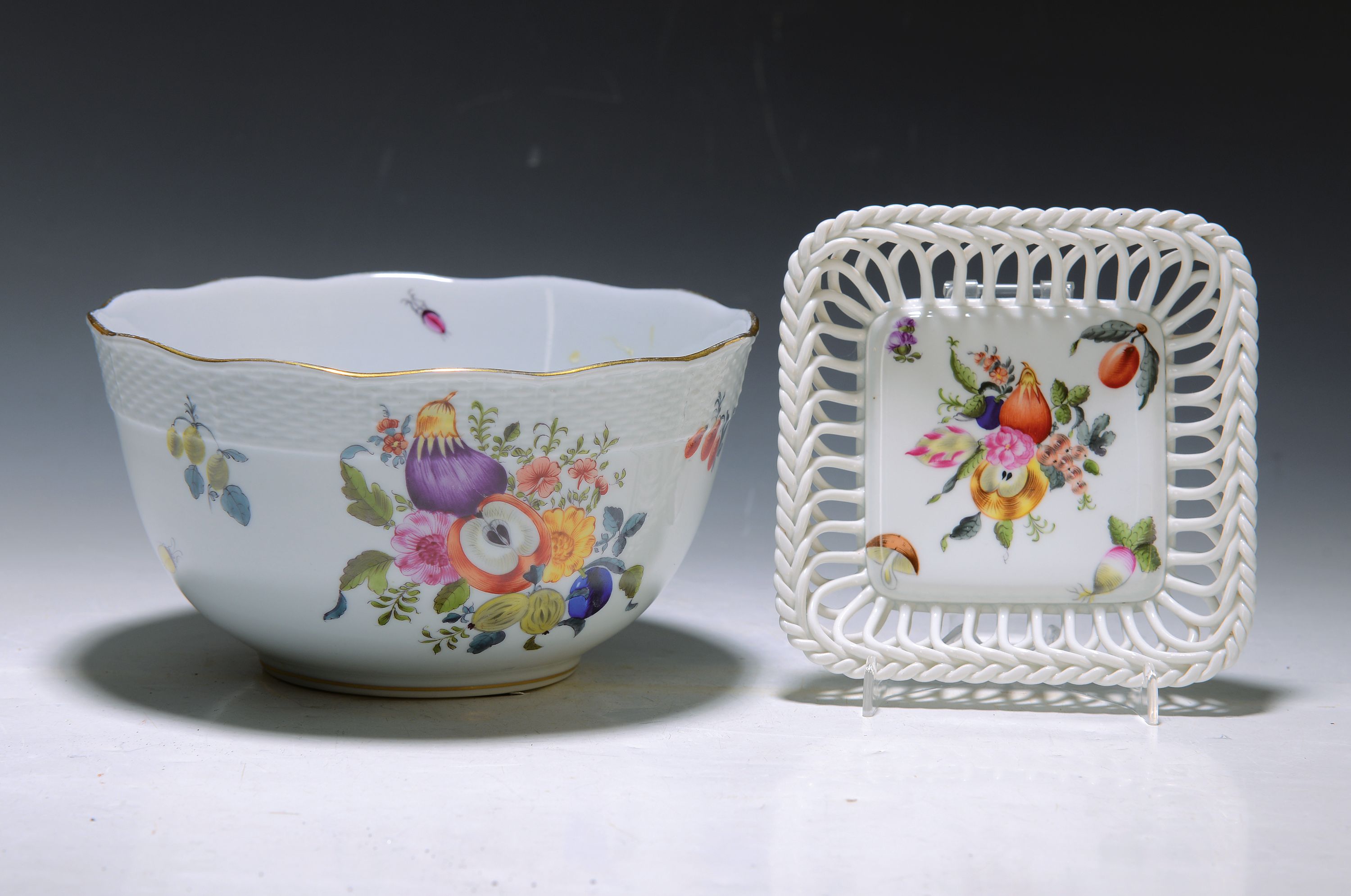 2 Schalen, Herend Ungarn, 20. Jh., 1x runde Schale, Rand korbartig reliefiert, bunter Dekor von Früchten und Blumen, Goldränder, H. ca. 10cm, D. ...