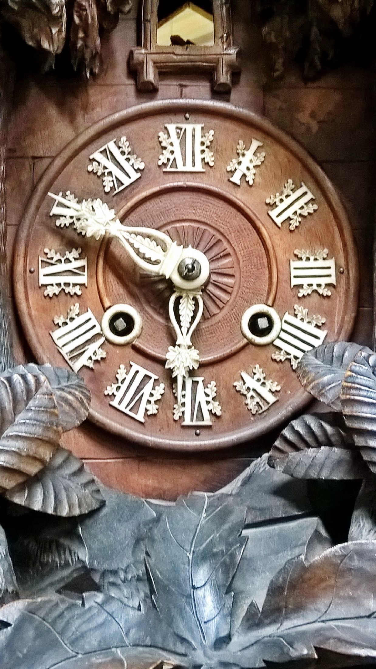 Detail a: Große Kuckucksuhr mit aufwendigem Werk, Schwarzwald um 1880, geschnitzte Front, Sockel dreiseitig mit stilisiertem Gestein, Holzgehäuse diagonal ...